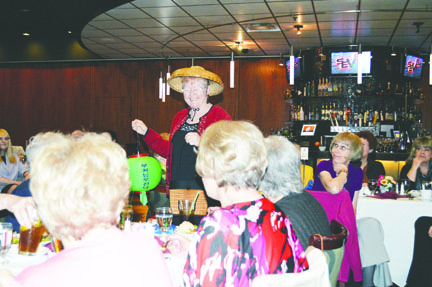 Sequim-Dungeness Hospital Guild Thrift Store volunteer Kathy Godbe models a Chinese New Year-inspired outfit she selected from the thrift store's shelves at the guild's annual fashion show Wednesday in Club Seven at 7 Cedars Casino. Models dressed up in holiday themes. Joe Smillie/Peninsula Daily News