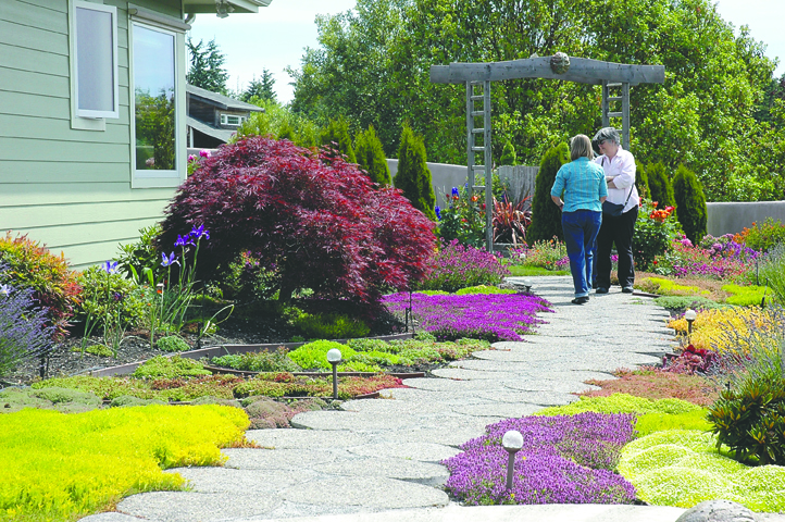 Two members of the Jefferson County Master Gardeners preview one of seven home gardens on today's Port Townsend Secret Garden Tour. Tickets are required to find the locations of the gardens on the tour.
