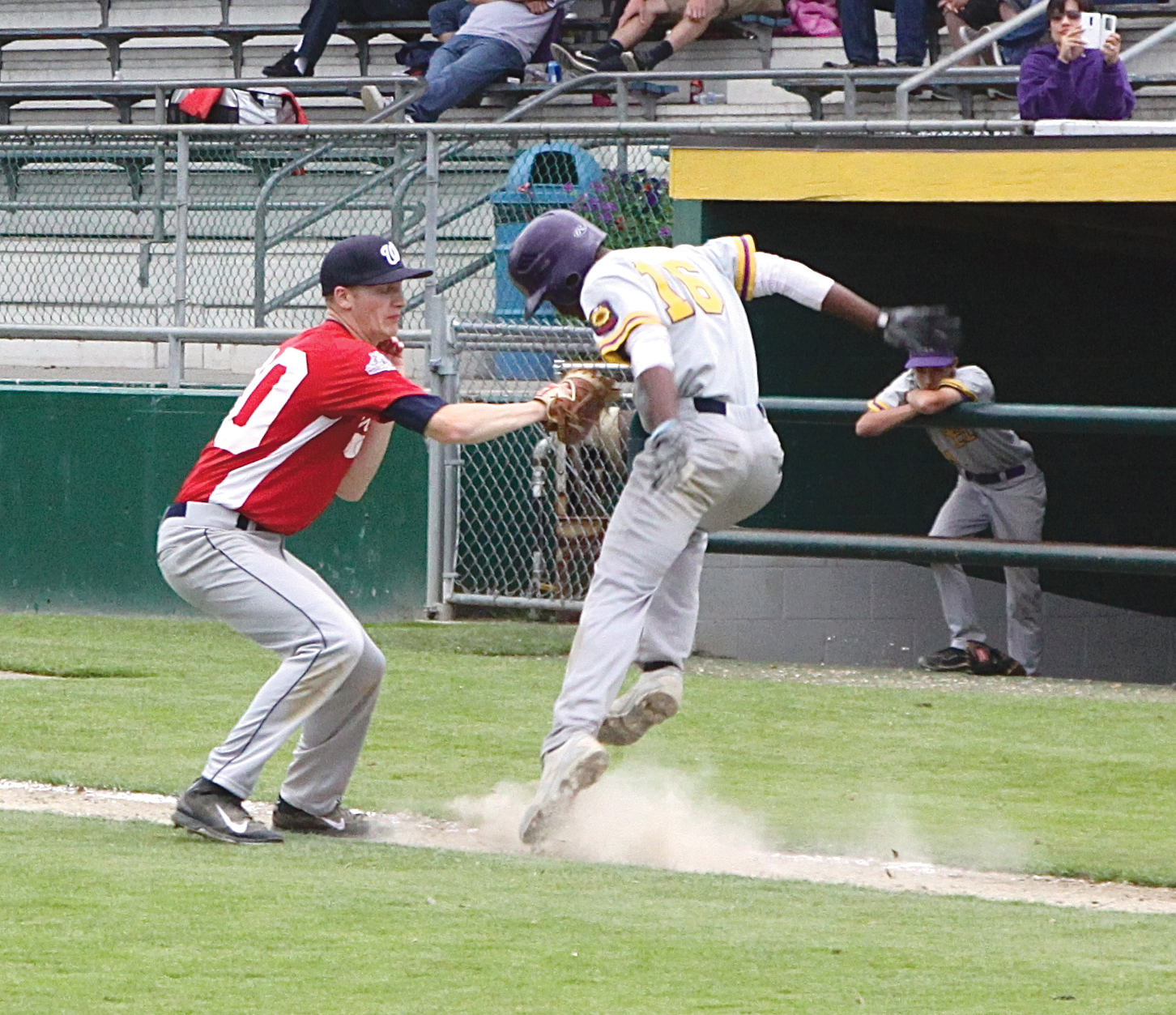 Wilder first baseman Larsson Chapman tags out Oak Harbor's Anthony Stewart (16) after Stewart bunted the ball along the first-base line. Dave Logan/for Peninsula Daily News