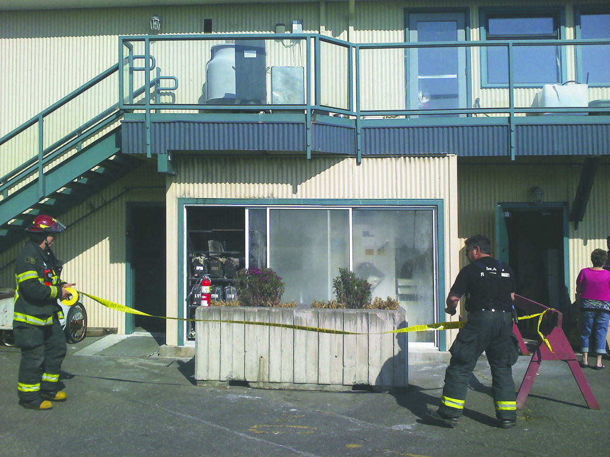 Port Angeles Fire Captain Terry Reid and engineer Dave Chastain set up barriers to keep people away from a battery room in The Landing mall after a second fire broke out in the room early Monday. Arwyn Rice/Peninsula Daily News