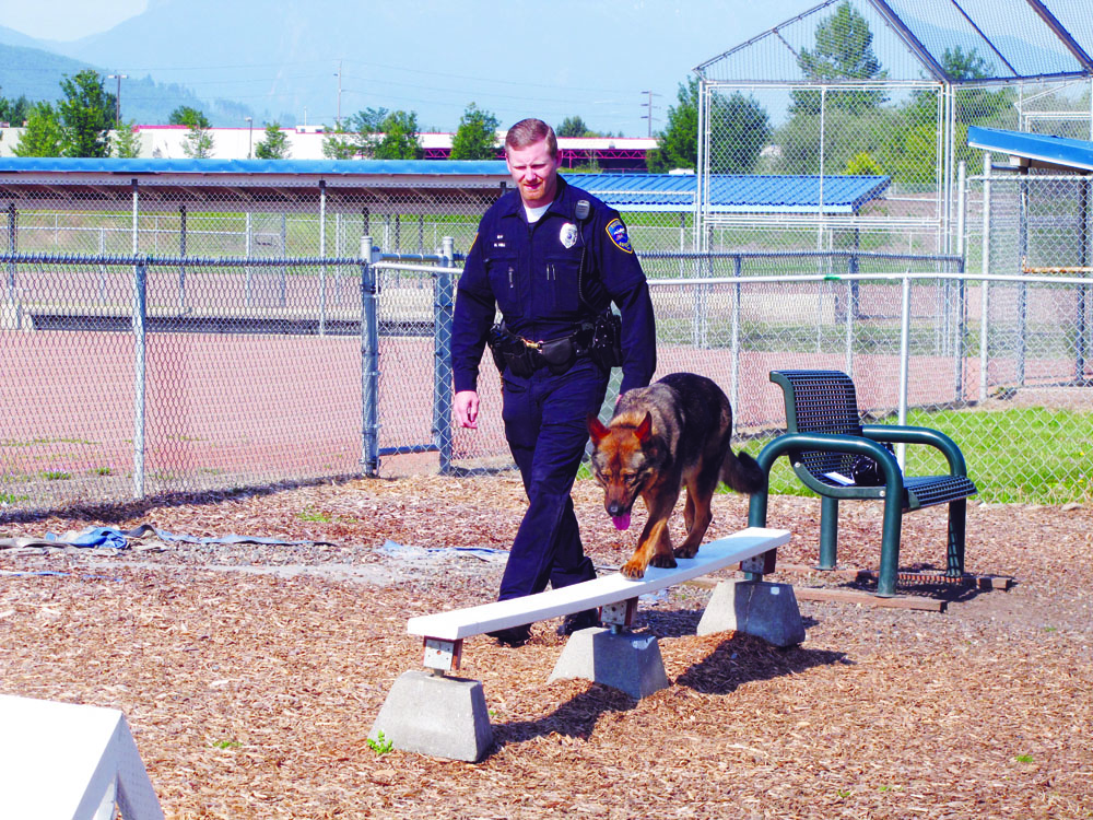 Officer Mike Hill of the Sequim Police with Chase at the new agility course in Sequim. Arwyn Rice/Peninsula Daily News