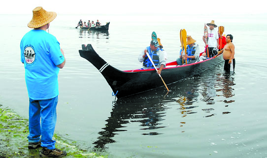Jamestown S'Klallam Chairman Ron Allen greets canoes Wednesday to Jamestown Beach. Keith Thorpe/Peninsula Daily News