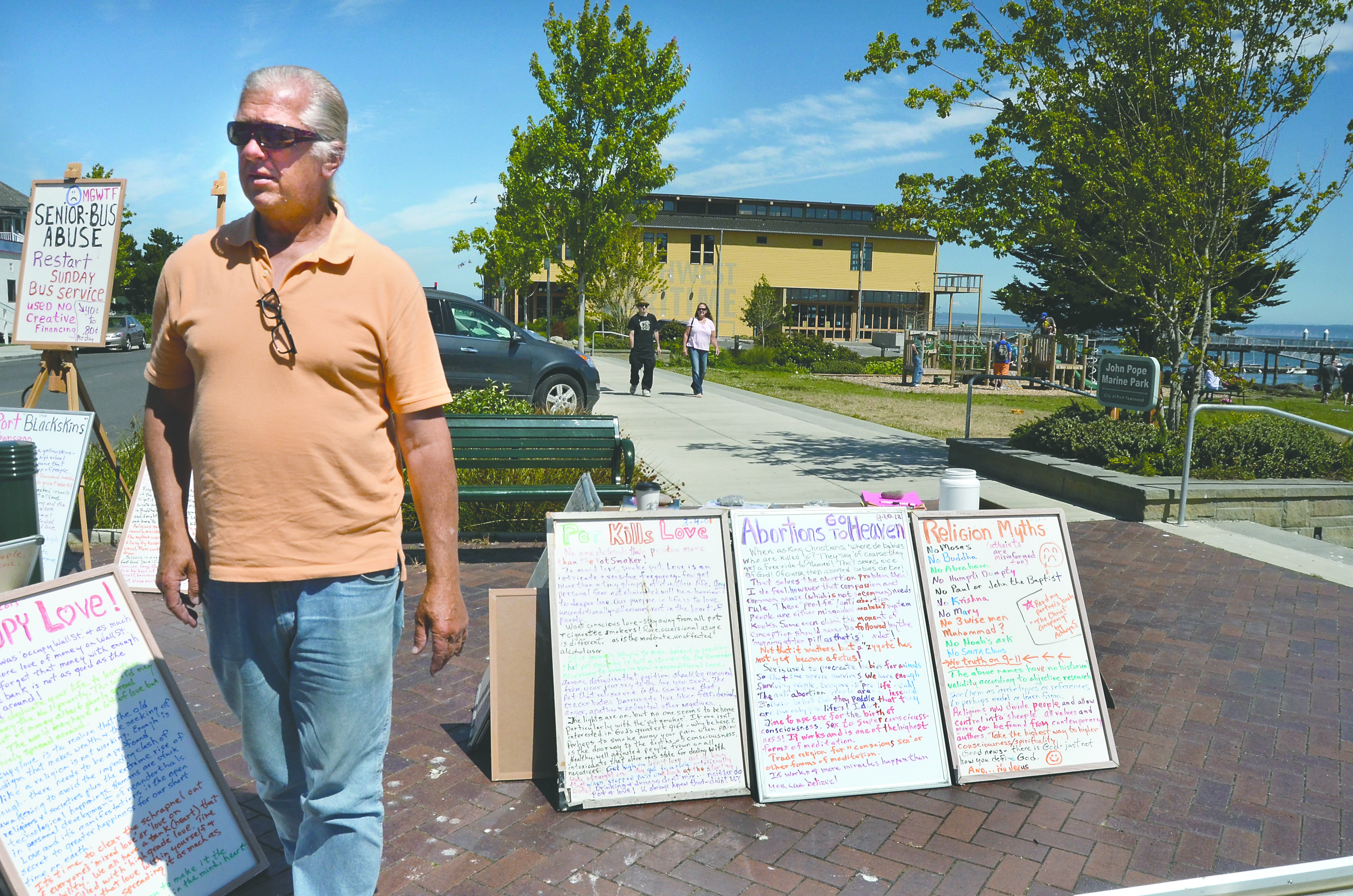 Arhata Osho and his array of signs at Pope Marine Park. Charlie Bermant/Peninsula Daily News