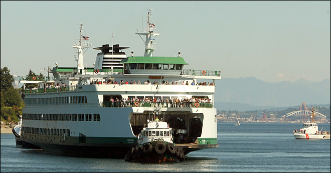 Tugboats bring the M/V Tacoma to dock after it lost power while traveling from Seattle to Bainbridge Island. The Associated Press