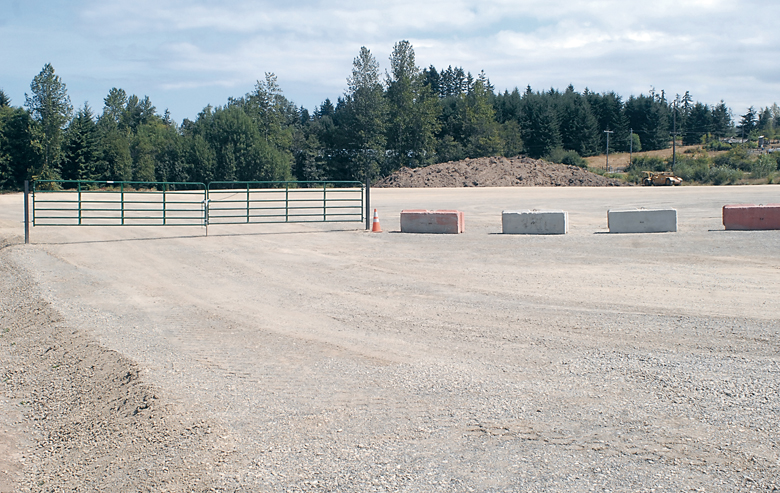 A gate and concrete barriers guard the entrance of a recently cleared and graded parcel on the northeast corner of U.S. Highway 101 and Fey Road southwest of Port Angeles. Keith Thorpe/Peninsula Daily News