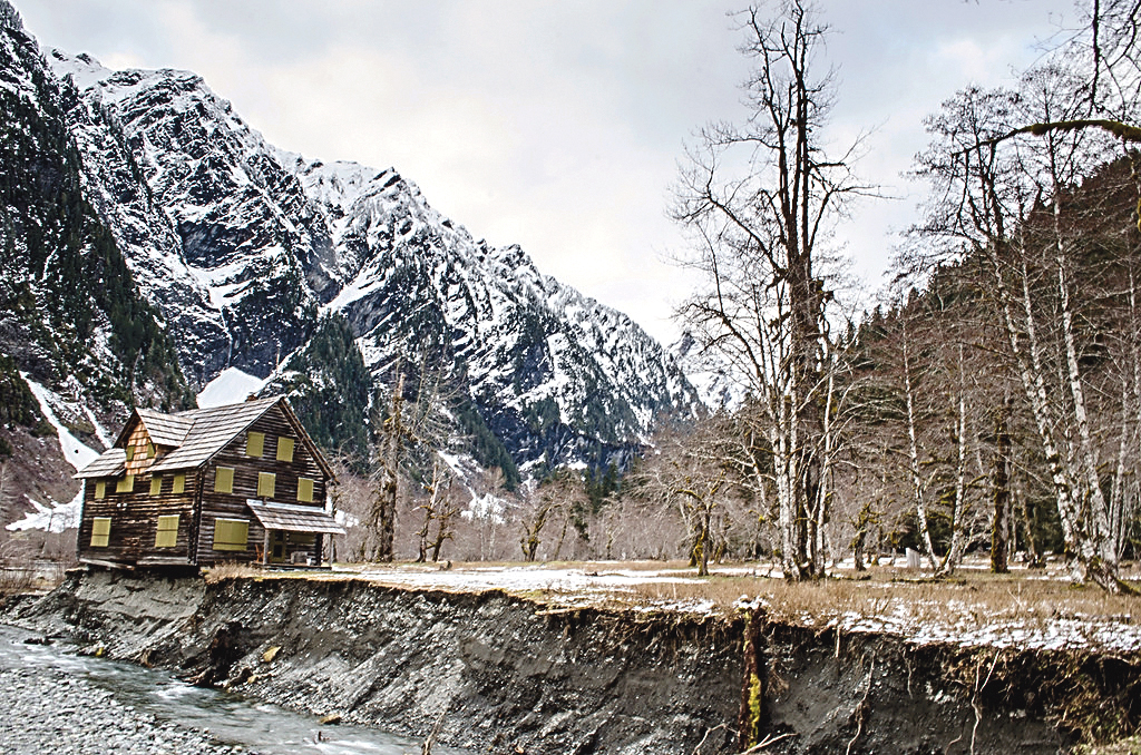 The Enchanted Valley Chalet is shown on the edge of the East Fork Quinault River. National Park Service