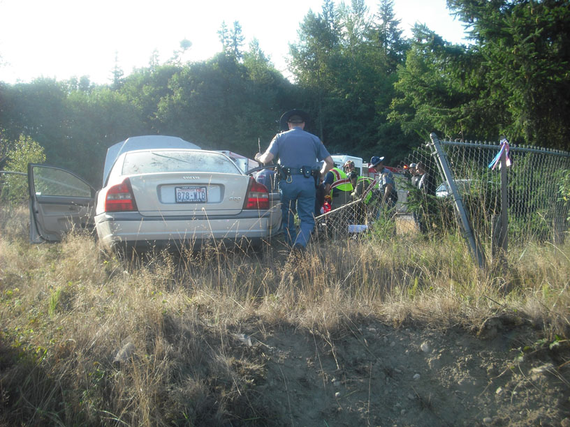 A Washington state trooper examines the Volvo that crashed near Barr Road in Port Angeles Sunday morning