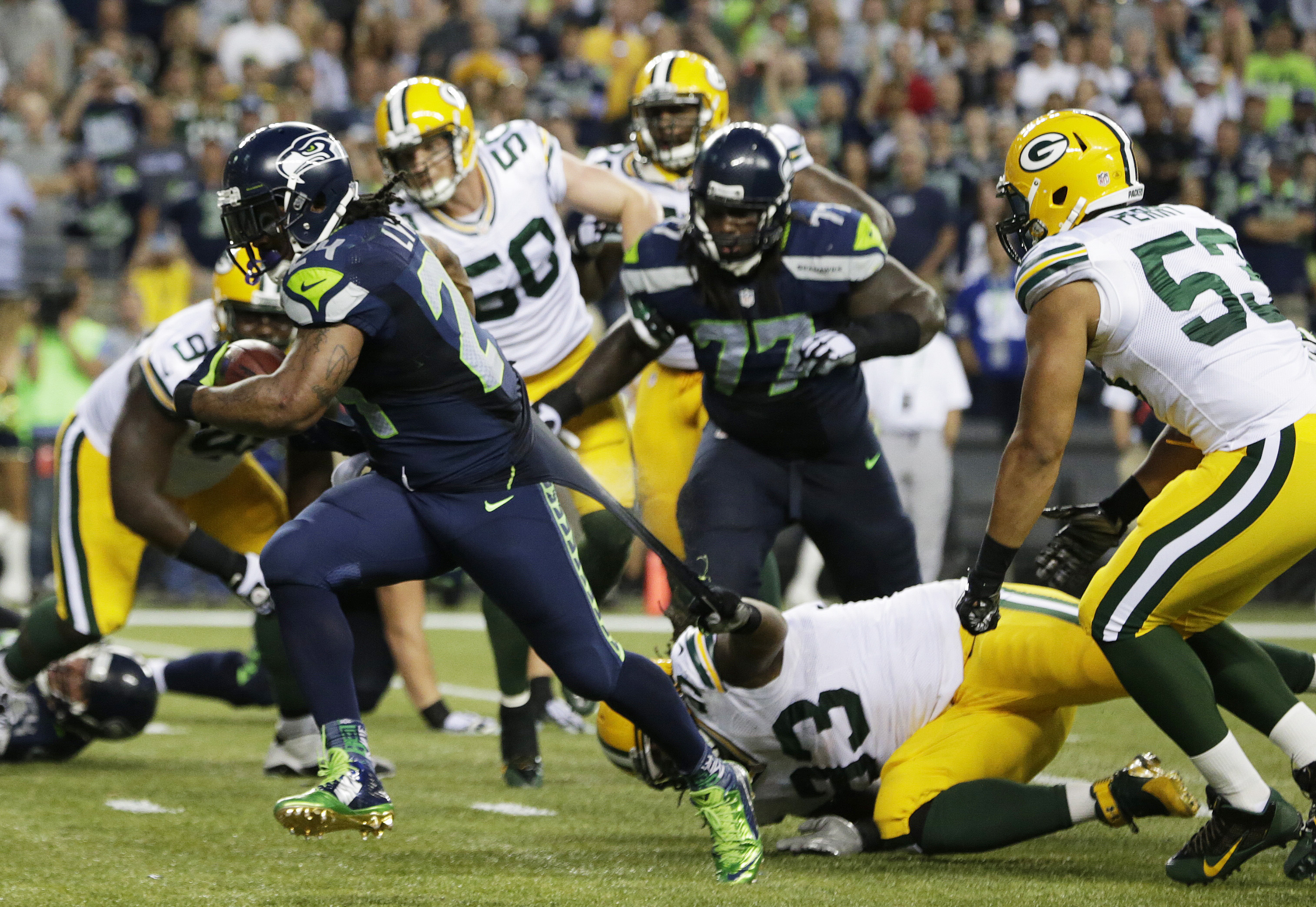 Green Bay Packers defensive end Josh Boyd (93) grabs the jersey of Seattle Seahawks running back Marshawn Lynch