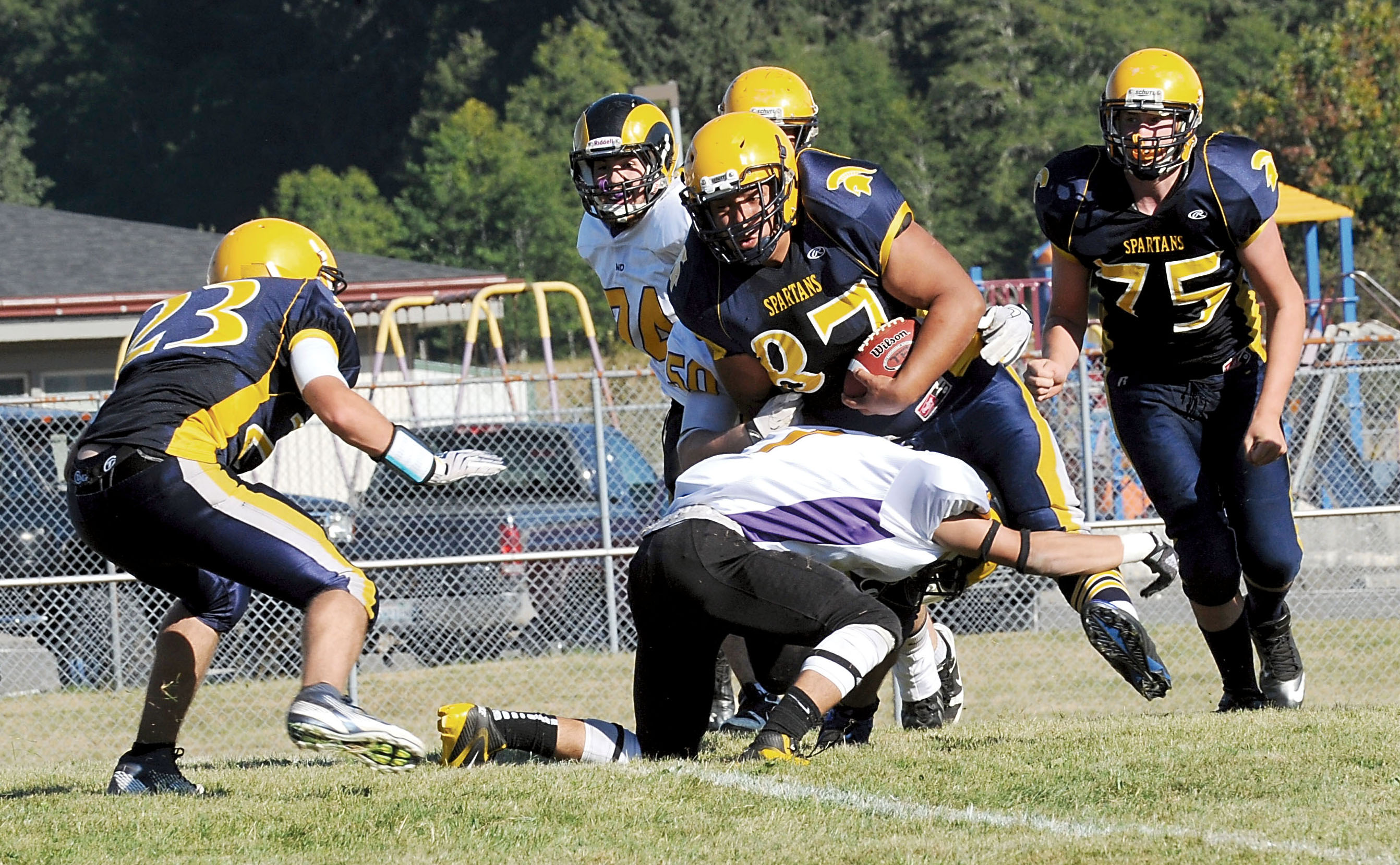 Forks running back Miquel Morales (87) is brought down after picking up yardage against Mount Douglas. Also in on the action for Forks are Kenny Gale (23) and Mark Adams. Lonnie Archibald/for Peninsula Daily News