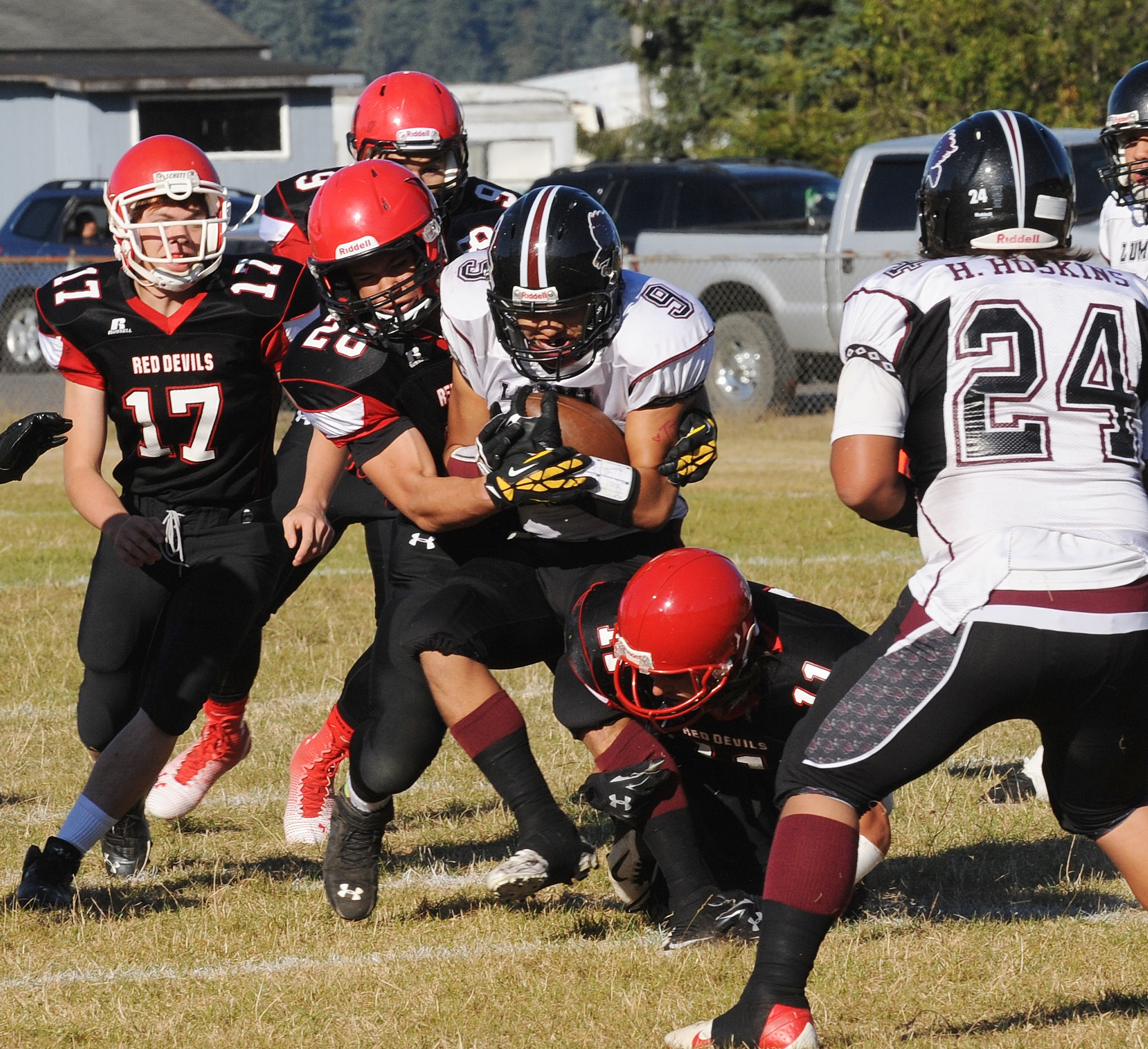 Neah Bay's Elisha Winck (28) and Josh Monette (11) team up to bring down Lummi's Devin Cooper (9) as Neah Bay's Tommy Tyler (17) and John Reamer join the fray. Lonnie Archibald/for Peninsula Daily News