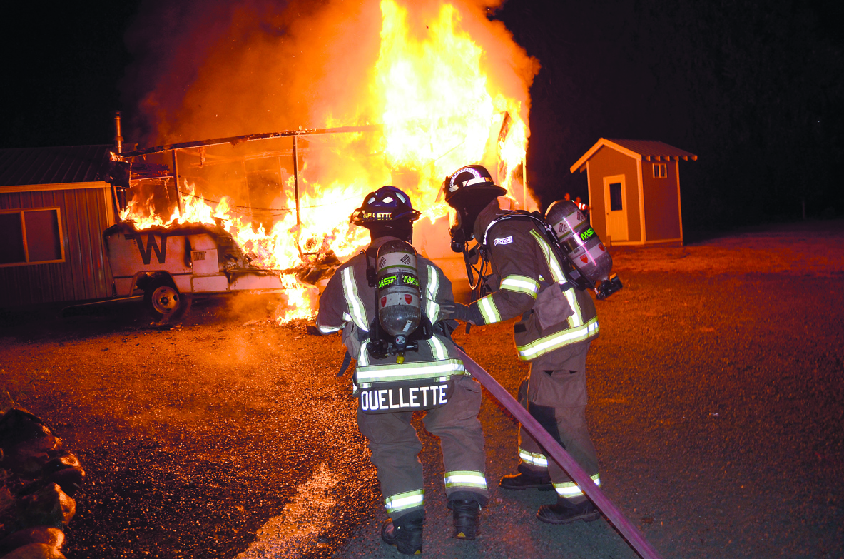 Firefighter-paramedics Brian Ouellette and Joel McKeen of Clallam County Fire District No. 3 prepare to attack a motor home fire on North Barr Road on Wednesday. Patrick Young/Clallam County Fire District No. 3