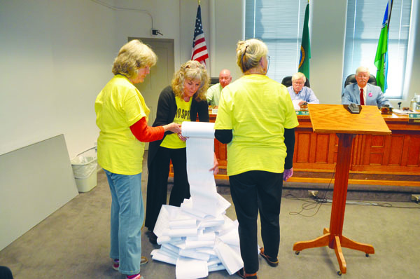 A petition is unscrolled by (from left) Elizabeth Skyhawk