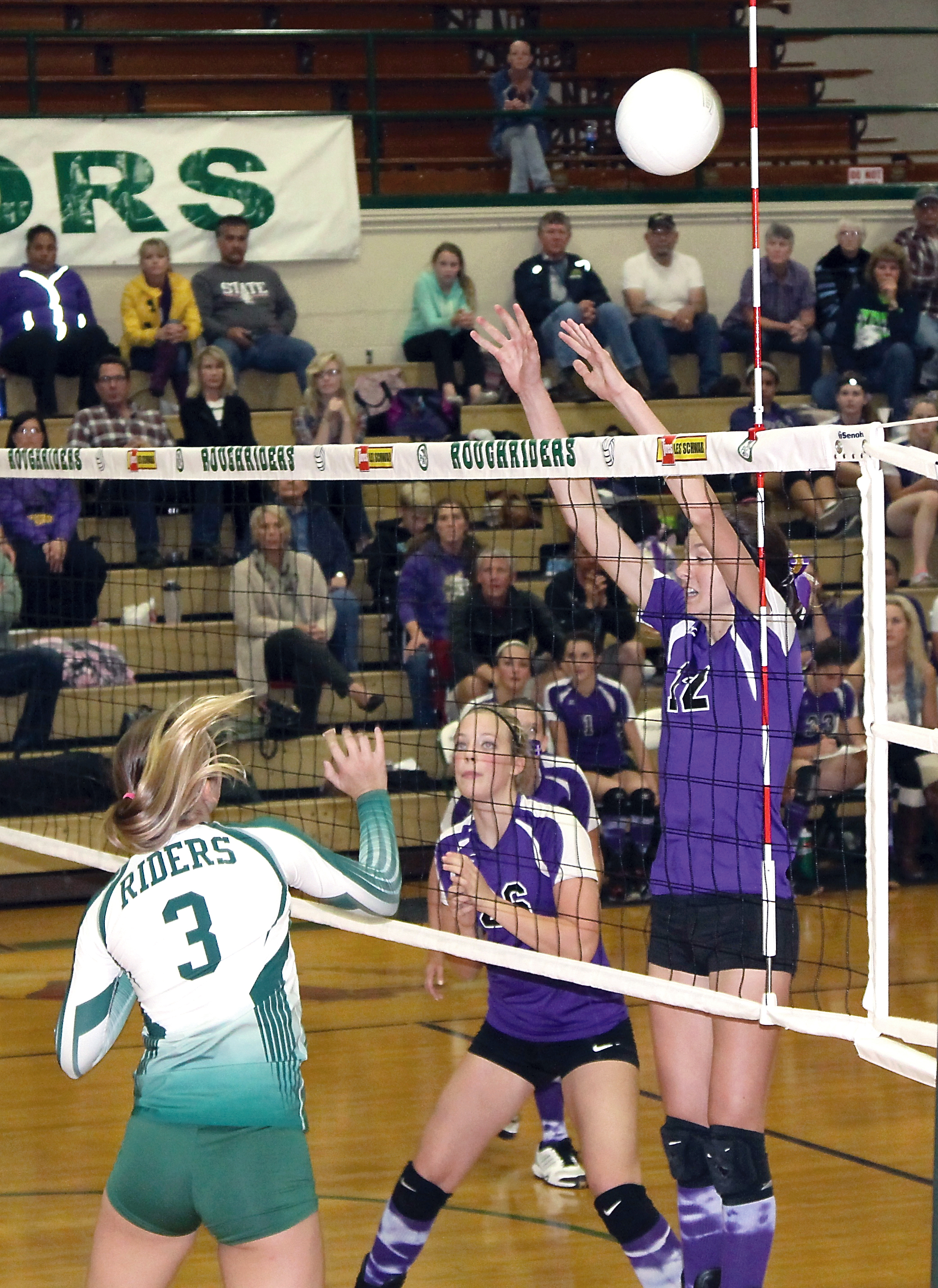 Port Angeles' Emily Johnson (3) battles Sequim's Megan Breckenridge (12) and Ella Christiansen (26) at the net. Dave Logan/for Peninsula Daily News
