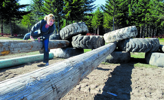 Kelie Morrison climbs over a log at a mud-filled obsticle for the Run A Muck Challenge today at the Extreme Sports Park in Port Angeles. Keith Thorpe/Peninsula Daily News