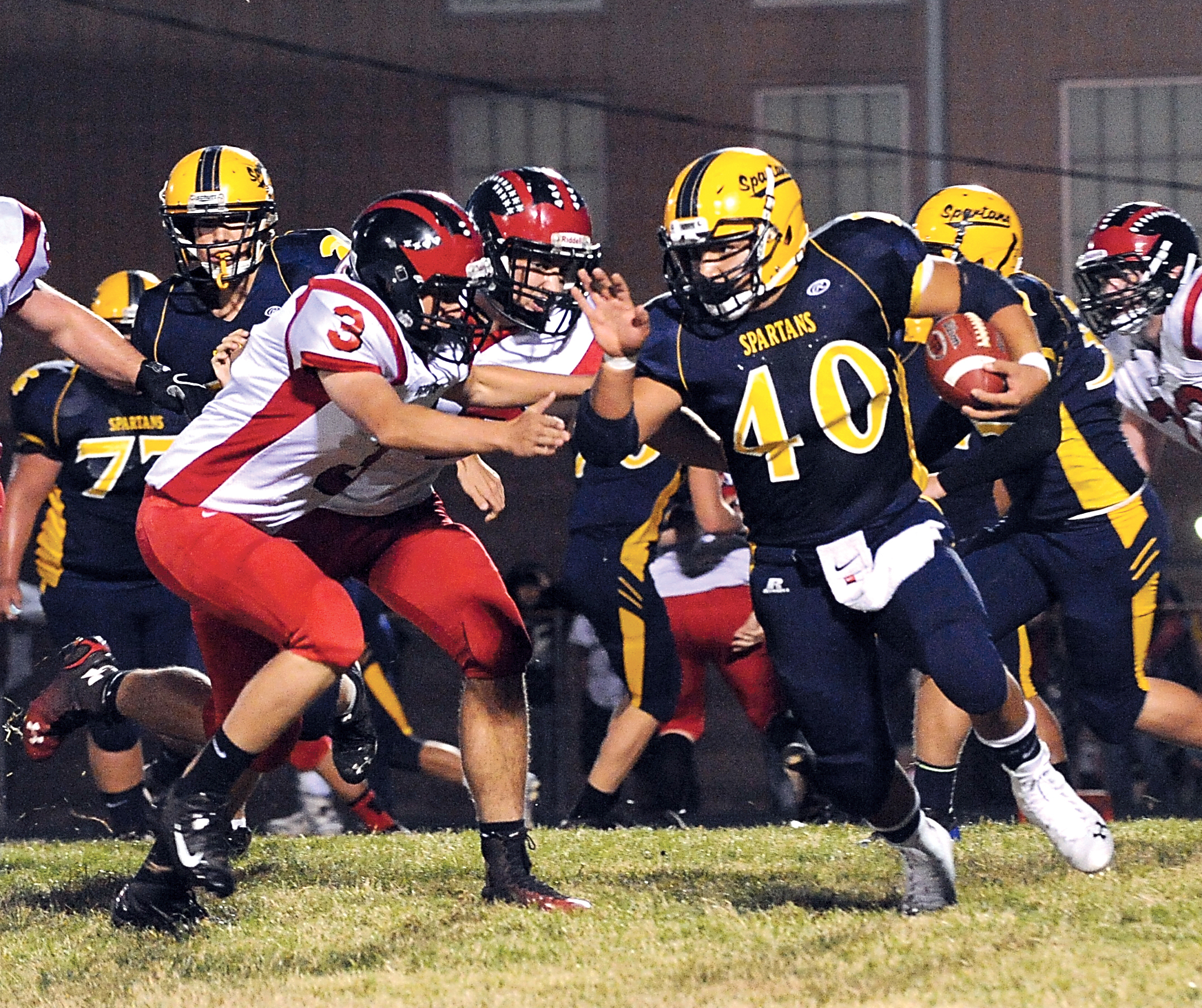 Forks running back Dimitri Sampson breaks loose from a pair of Tenino defenders to score on a 76-yard touchdown run for the Spartans in the first quarter of Forks' 20-19 win. Lonnie Archibald/for Peninsula Daily News