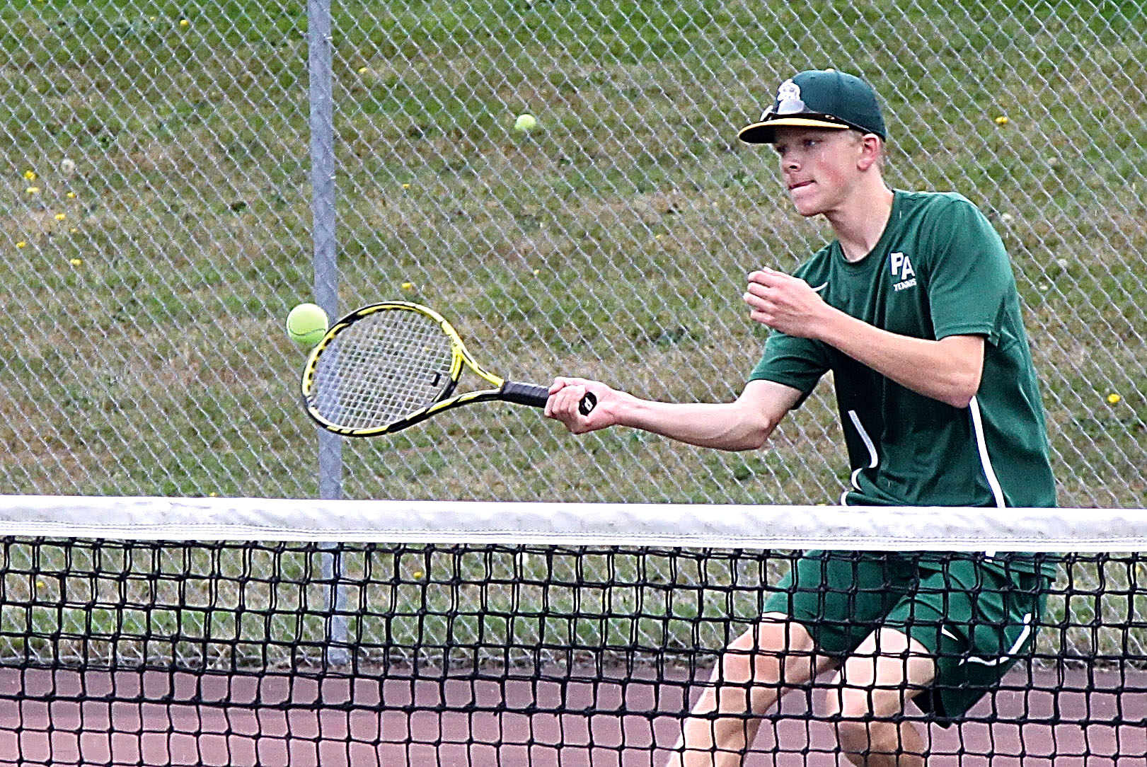 Port Angeles' Janson Pederson hits to Sequim's Matthew Richards during Monday's play before the match was delayed due to rain. The Roughriders went on to win the match 4-3 when play resumed. Dave Logan/for Peninsula Daily News