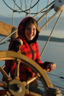 A young girl at the Adventuress' now-missing wheel. This photo is posted at the schooner's website
