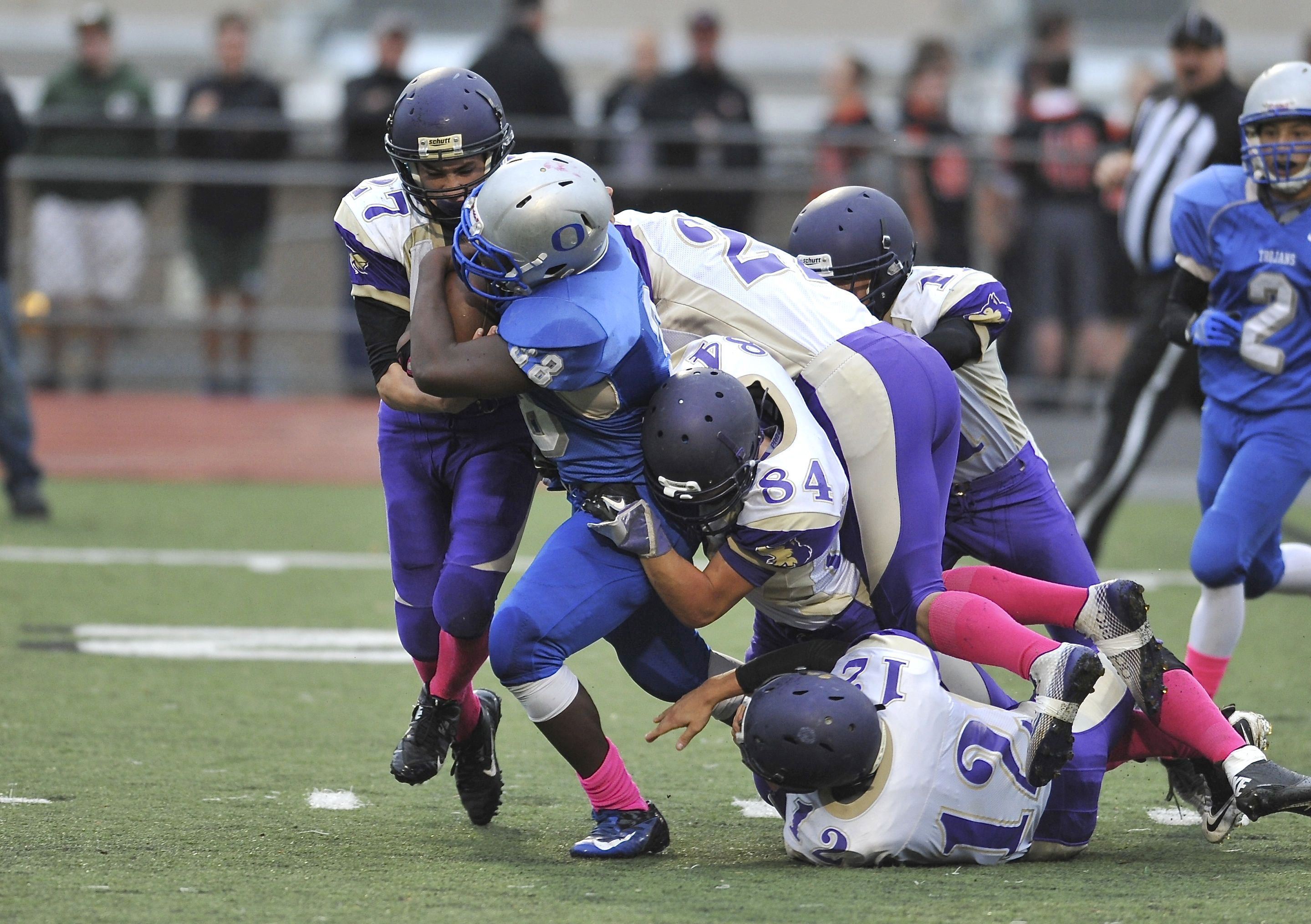 Olympic's R.J. Enriquez (48) is slowed by a pack of Sequim Wolves
