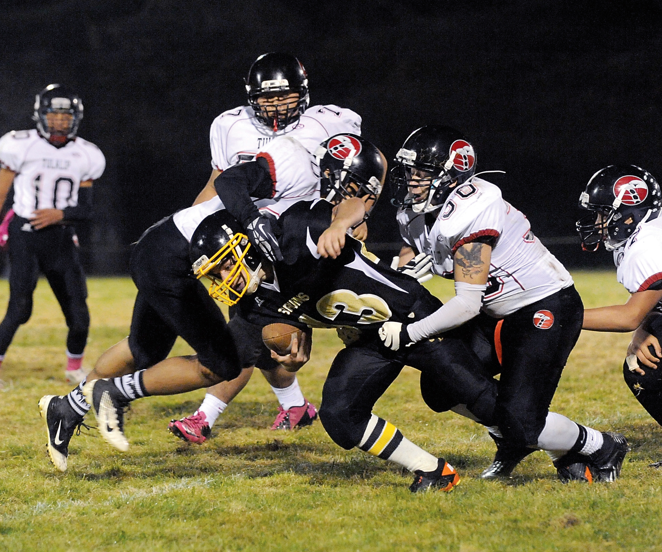 Clallam Bay running back Casey Randall stretches for an extra yard against a pack of Tulalip Heritage tacklers. Lonnie Archibald/for Peninsula Daily News