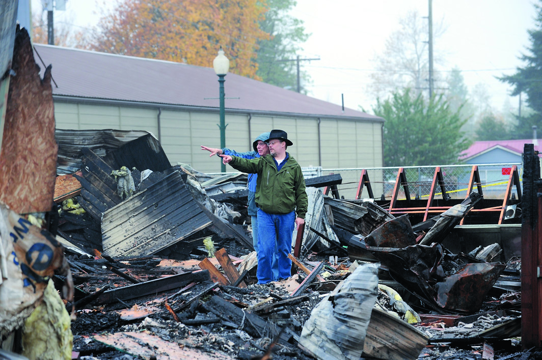 Forks City Attorney Rod Fleck looks over the fire scene with insurance representative Roger Neal. Lonnie Archibald/for Peninsula Daily News