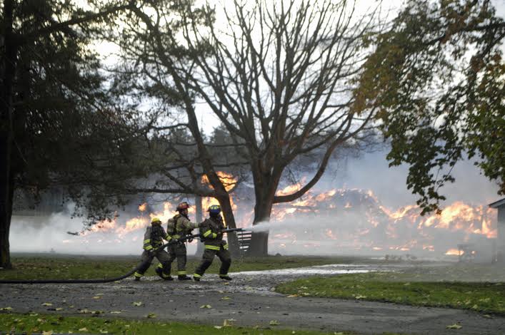 Firefighters battle a barn blaze northeast of Sequim on Friday. Chris McDaniels/Peninsula Daily News