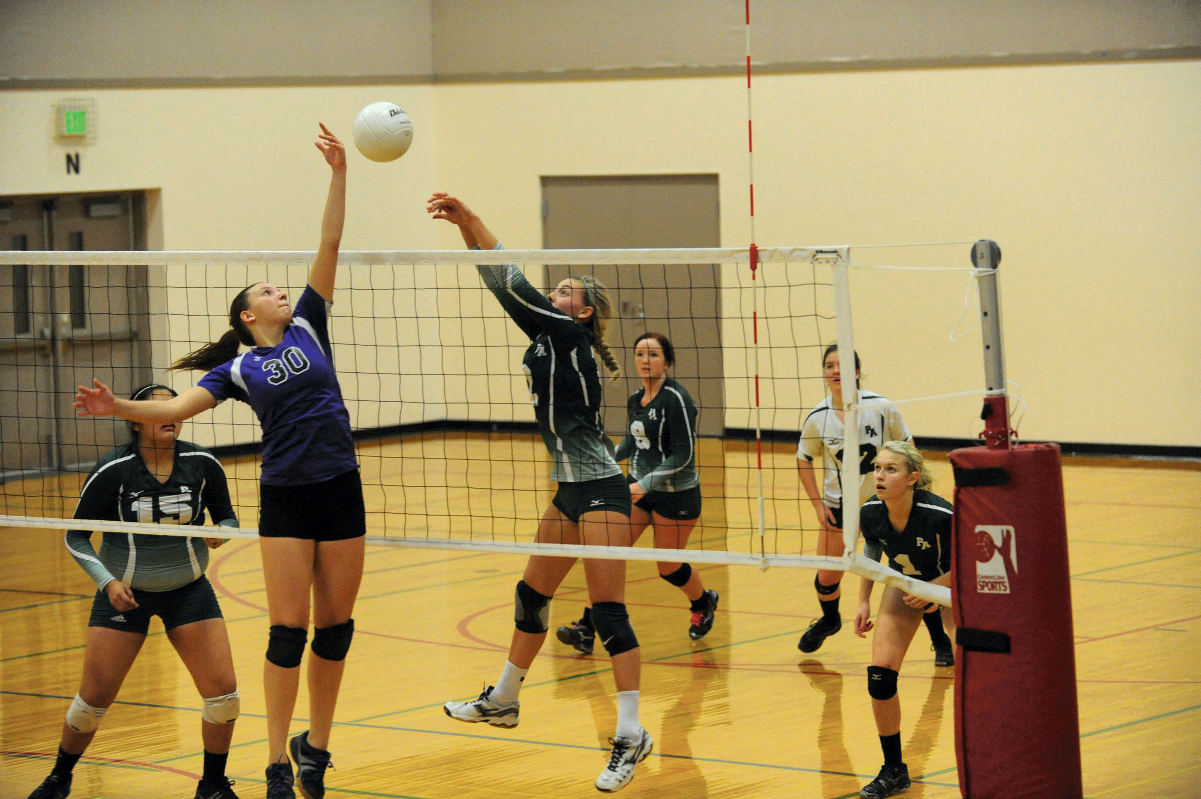 Sequim's Alyse Armstrong (30) and Port Angeles' Maddy Hinrichs (2) compete at the net. Lonnie Archibald/for Peninsula Daily News