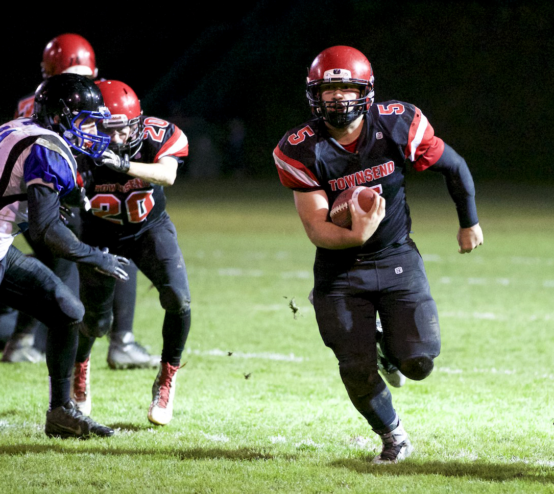 Port Townsend's David Sua (5) blasts through a hole opened up by Kyle Blankenship (20) and Keegan Khile during the Redhawks' 51-8 district playoff victory against Bellevue Christian at Memorial Field. Steve Mullensky/for Peninsula Daily News
