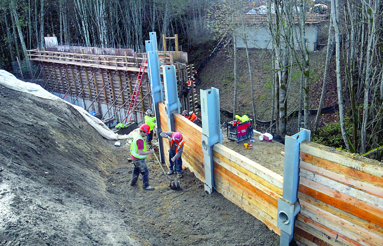 Workers with Seattle-based Scarsella Brothers Inc. assemble a retaining wall that will become part of an approach lane to the Lauridsen Boulevard bridge over Peabody Creek in Port Angeles on Thursday. Keith Thorpe/Peninsula Daily News