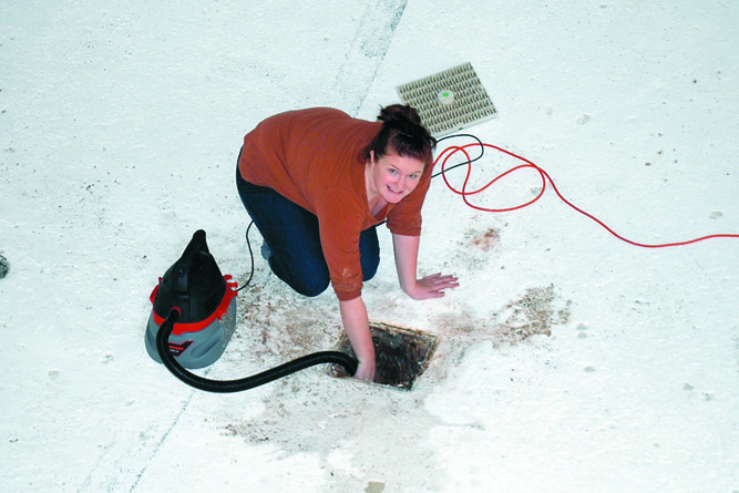 Mountain View Pool Manager Anji Scalf vacuums a vent at the pool in preparation for needed repairs. Charlie Bermant/Peninsula Daily News