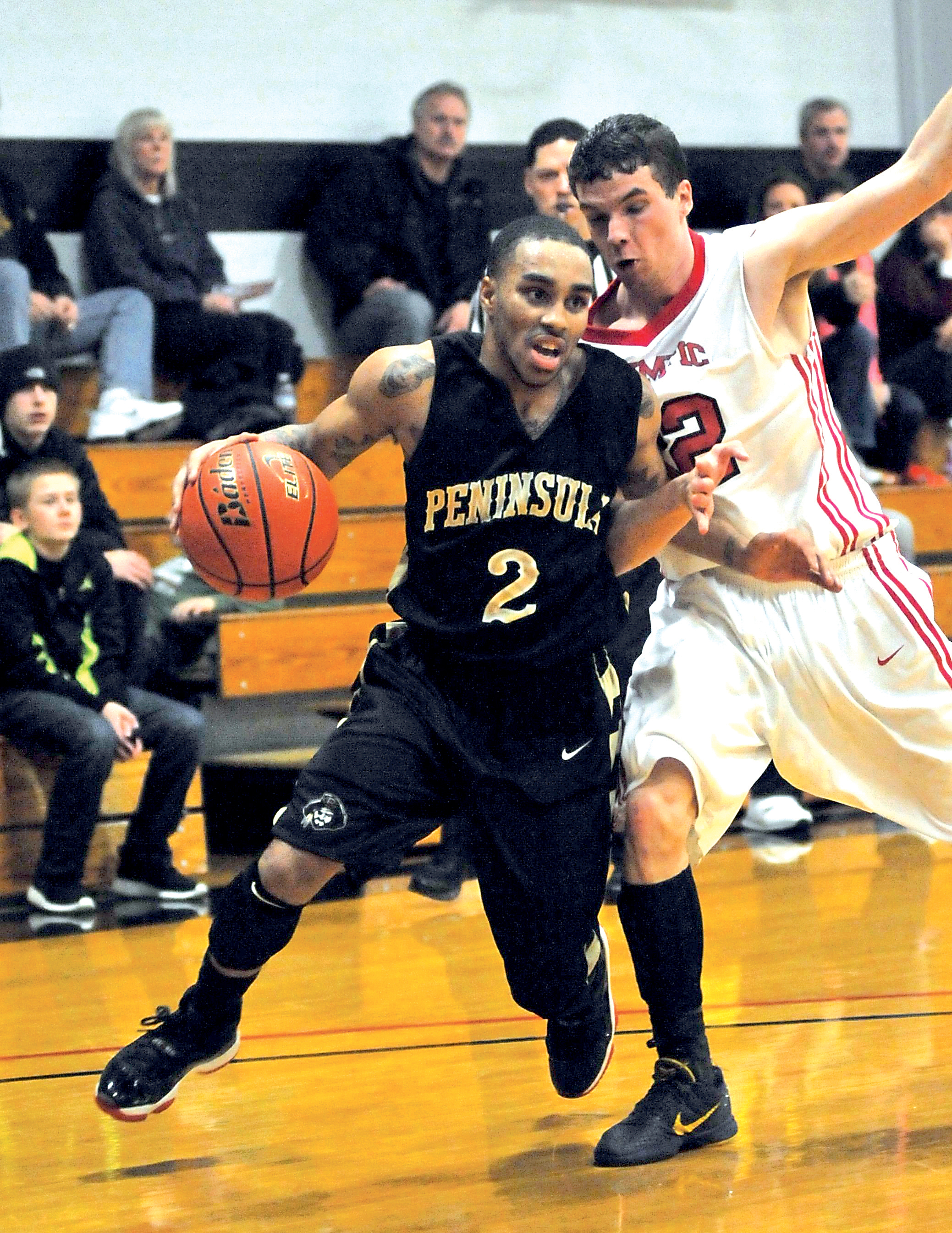 Peninsula College's Geno Horsely drives around Olympic's Jayson Brocklesby