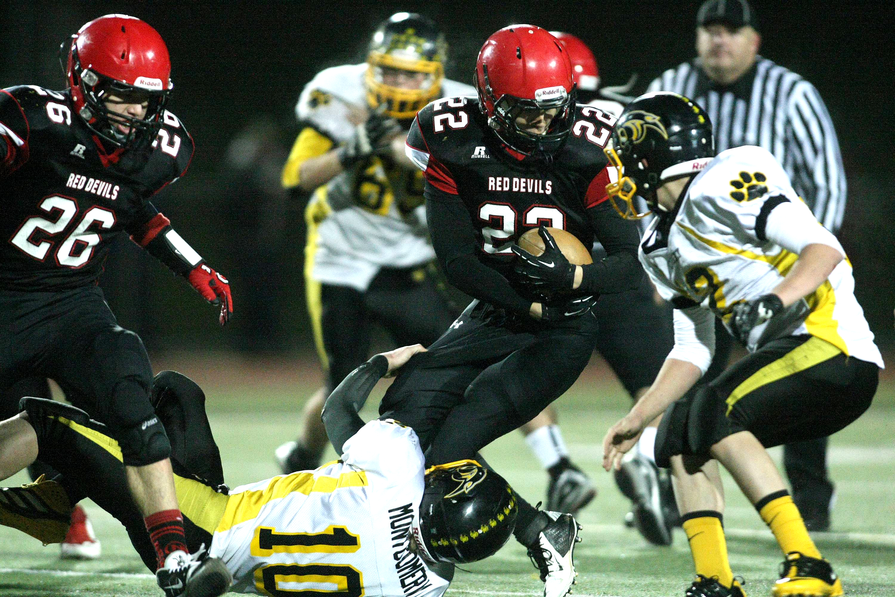Neah Bay running back Cody Cummins (22) battles for extra yards late in the second half while Cusick's Quinton Montgomery (10) and Tyson Shanholtzer (12) get in on the tackle. David Willoughby/for Peninsula Daily News