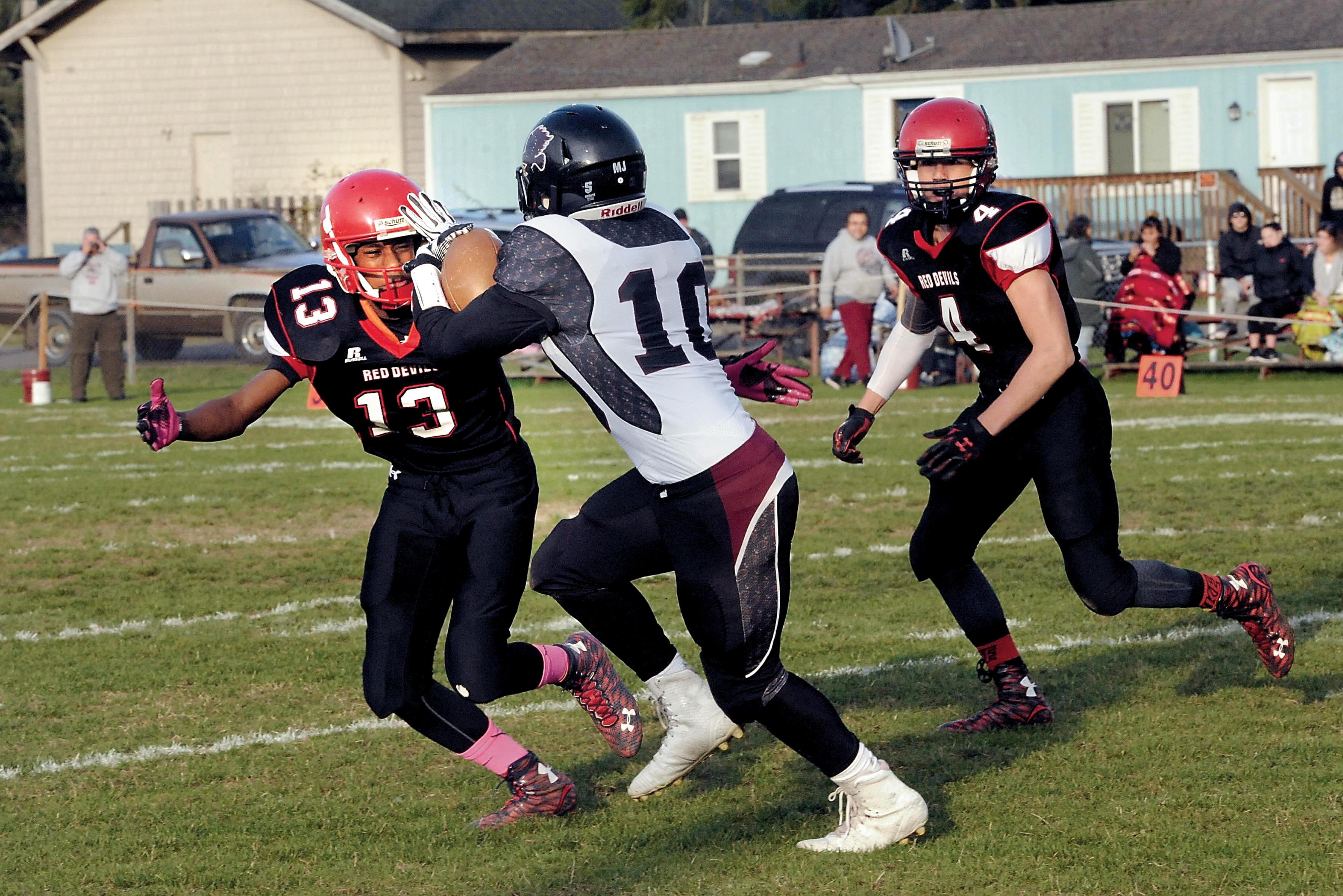 Neah Bay's Anthony Bitegeko (13) prepares to tackle Lummi's Dashawn Lawrence (10) as Roland Gagnon runs to help during the Red Devils 62-12 victory over the Blackhawks earlier this season. The two teams meet for the fourth consecutive year in the state semifinals today at 1 p.m. at the Tacoma Dome. Lonnie Archibald/for Peninsula Daily News
