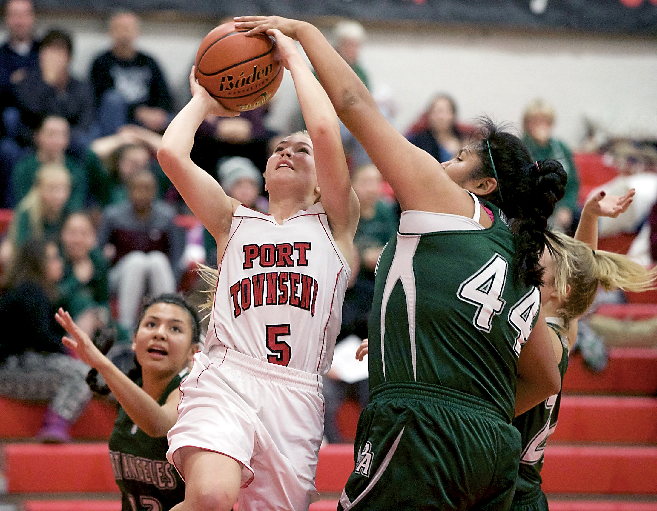 Port Townsend's Kaitlyn Meek draws a foul from Port Angeles' Nizhoni Wheeler. Steve Mullensky/for Peninsula Daily News