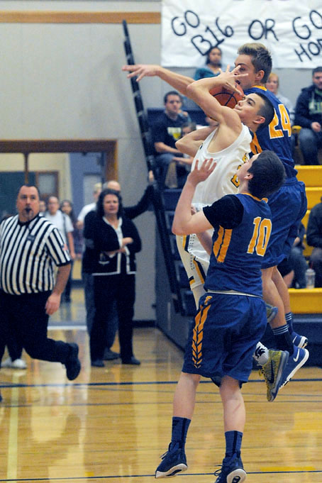 Forks' Jeffrey Schumack drives against Rochester's Riley Erickson (10) and Brock Hawes (24) during the Spartans' 57-48 win. Shumack scored seven points. Lonnie Archibald/for Peninsula Daily News