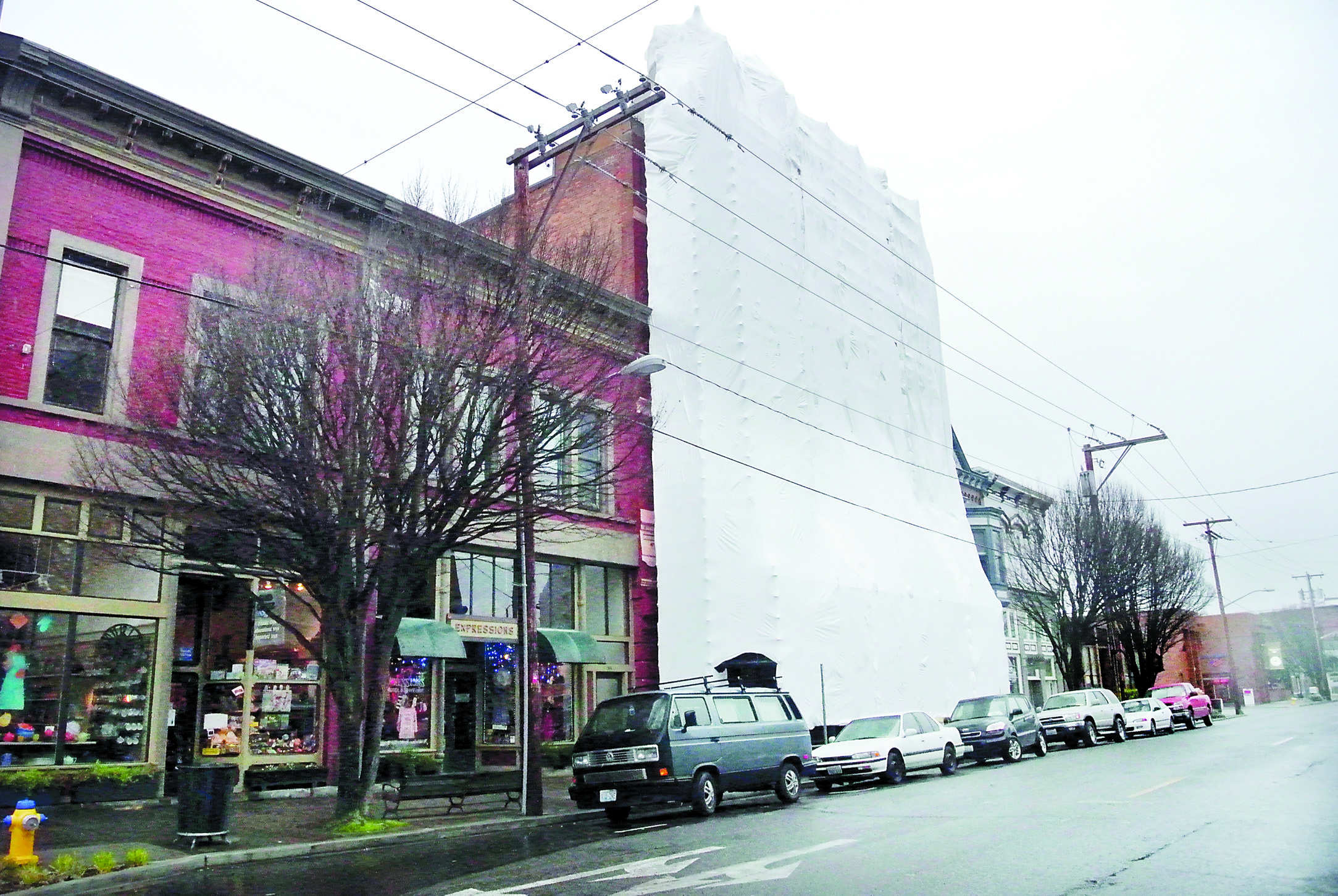 The replacement of the Eisenbeis Building’s facade — now covered to protect workers from the weather — is expected to take three to four months. -- Photo by Charlie Bermant/Peninsula Daily News