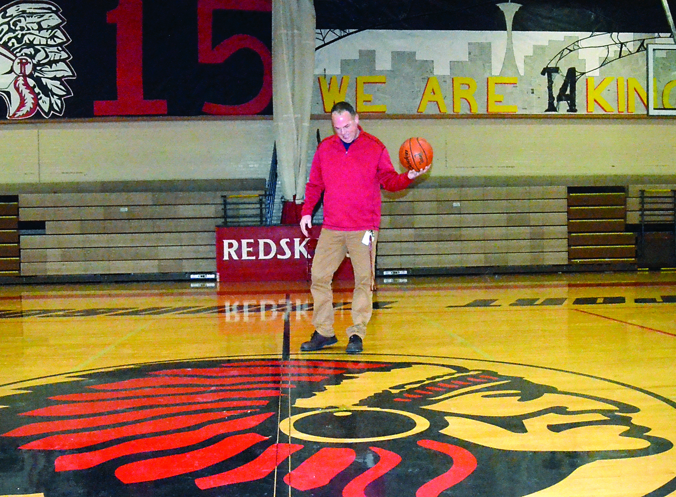 Port Townsend High School Athletic Director Scott Wilson inspects the Redskins logo on the floor of the high school gym. — Charlie Bermant/Peninsula Daily News