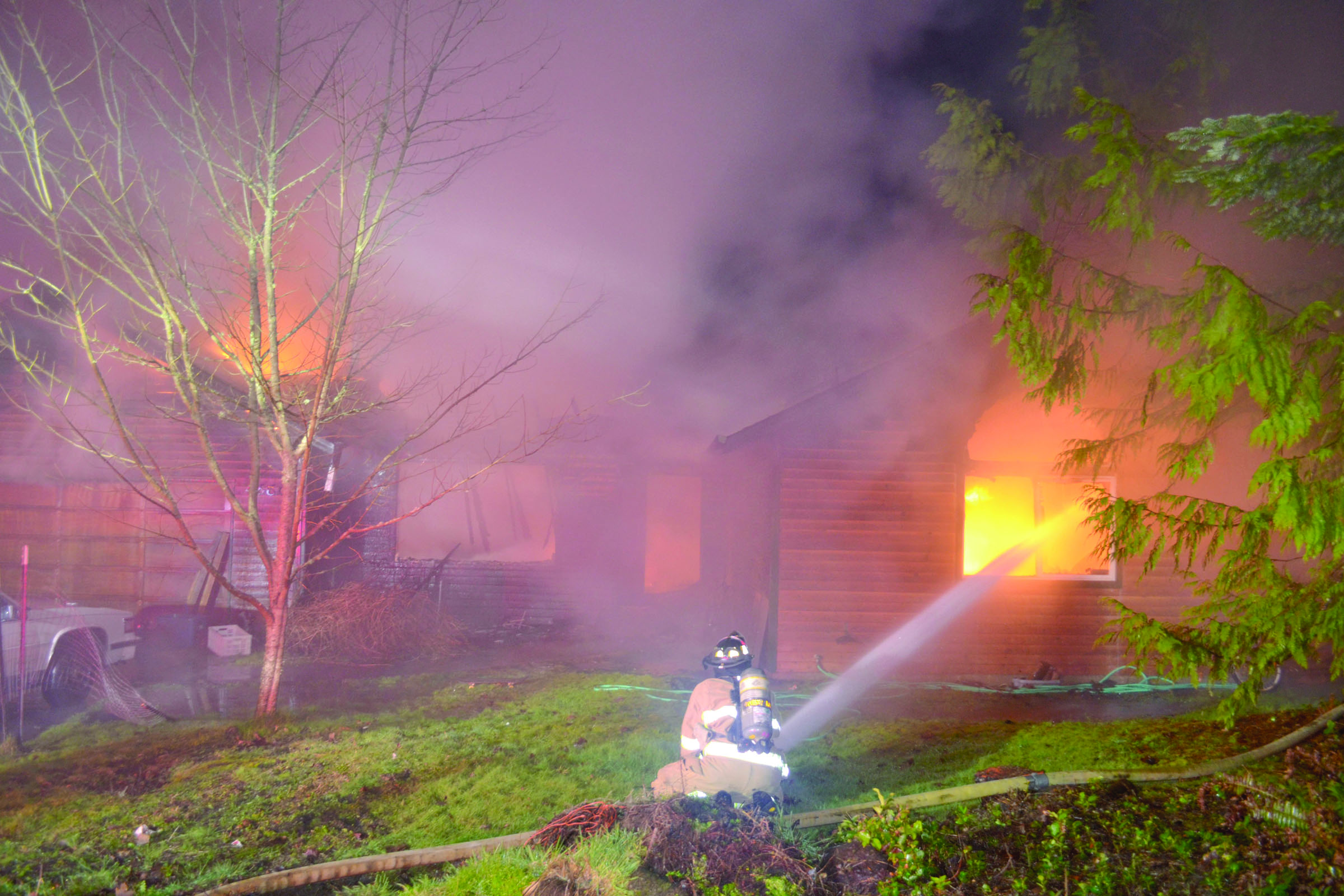 A firefighter battles a house fire on Holcomb Street in Port Townsend early this morning. Bill Beezley/East Jefferson Fire Rescue