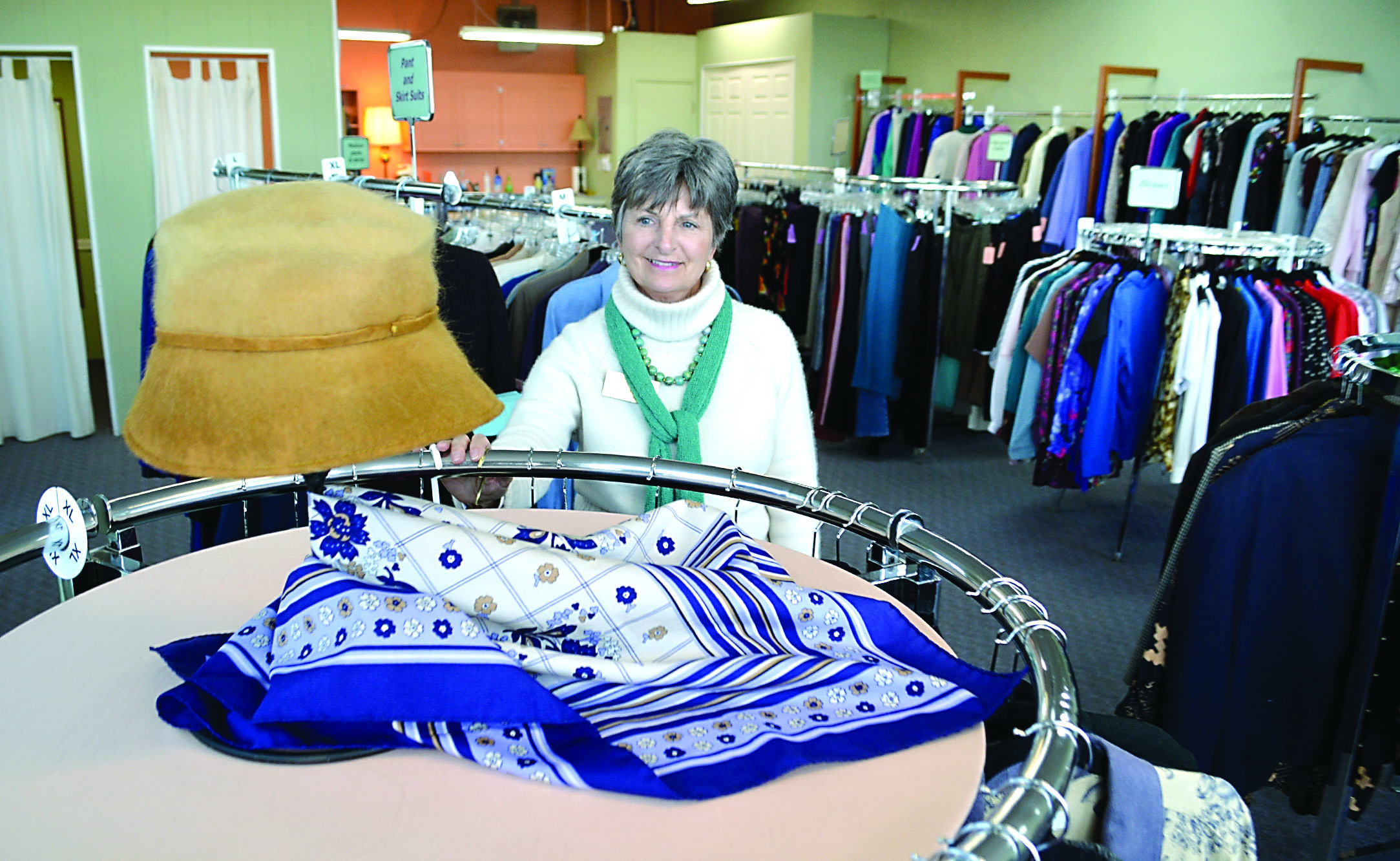 Long-time worker Janet Littlefield shows off a hat in the Museum & Arts Center’s Second Chance Consignment Shop at 155 W. Cedar St. The hat and everything else in the store will be on sale for $1 for the next week until the store closes for good Feb. 25. — Joe Smillie/Peninsula Daily News
