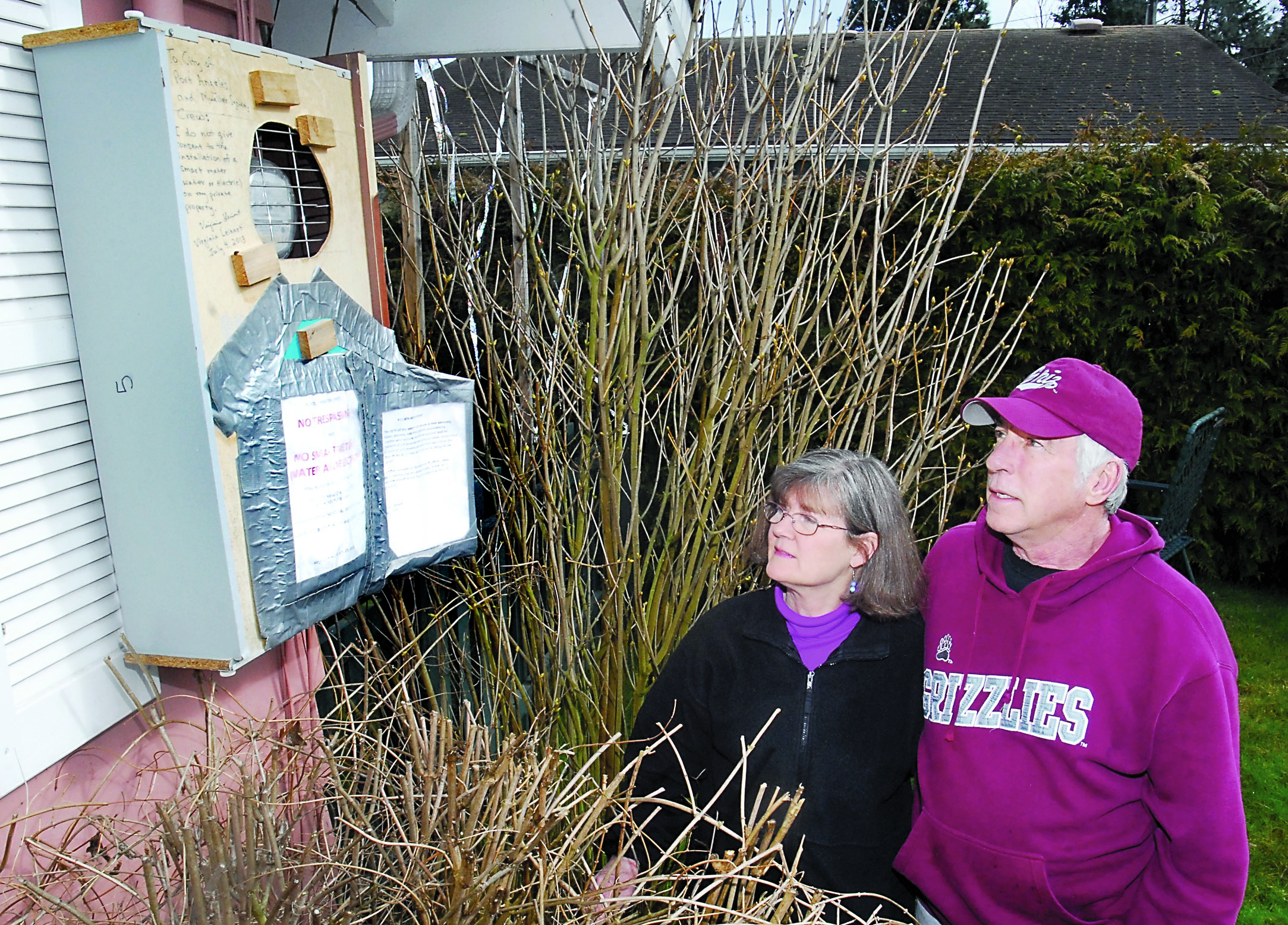 Virginia and Tom Leinart look at a box they have built around the electric meter of their Port Angeles home to prevent the city from installing a “smart” meter at their residence. — Keith Thorpe/Peninsula Daily News