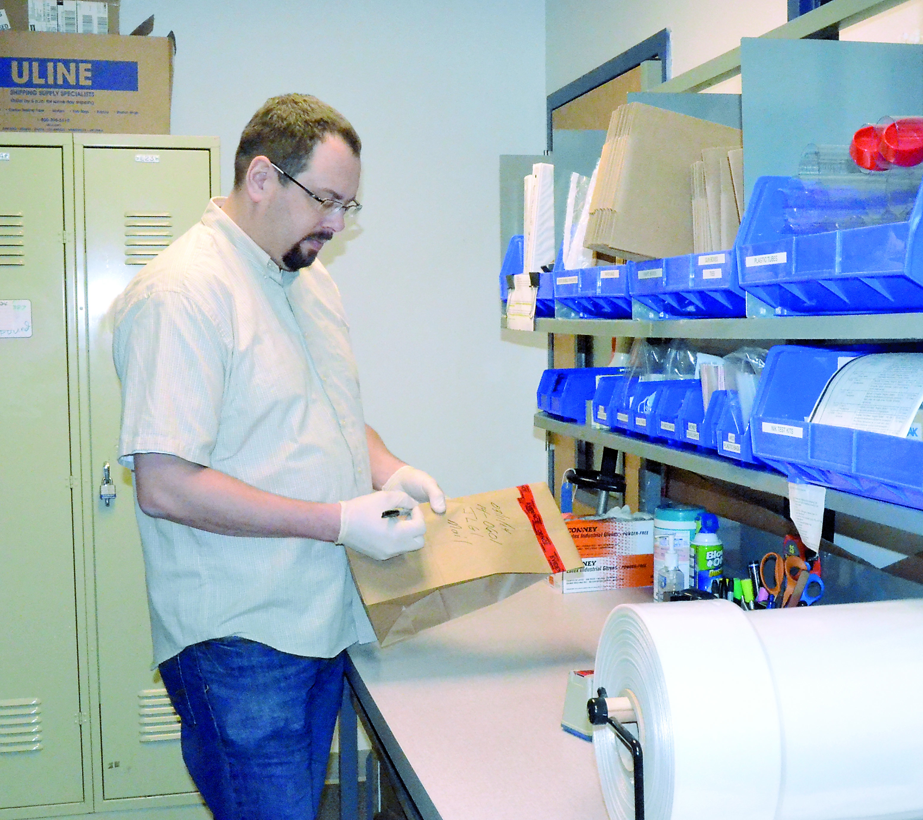 Port Townsend Police Detective Jason Greenspane demonstrates the process that will be used to return items of stolen mail to the U.S. Postal Service. — Charlie Bermant/Peninsula Daily News