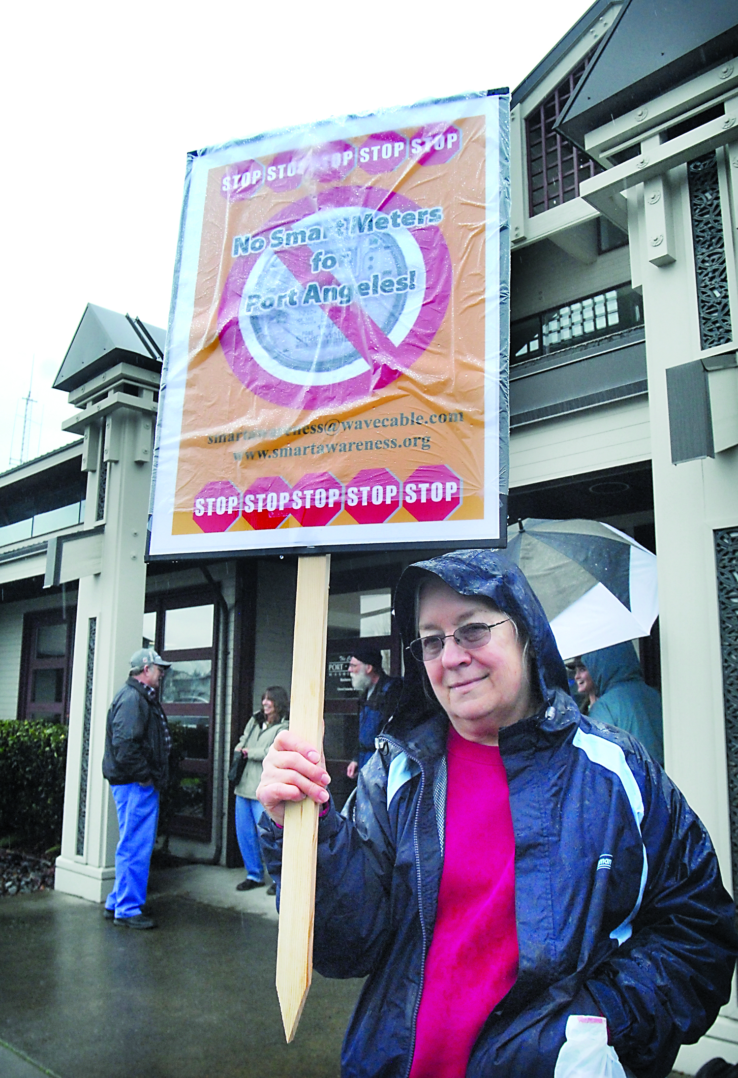 Linda Crane of Port Angeles holds up a sign against the deployment of “smart” meters during an informational protest outside Port Angeles City Hall. — Keith Thorpe/Peninsula Daily News