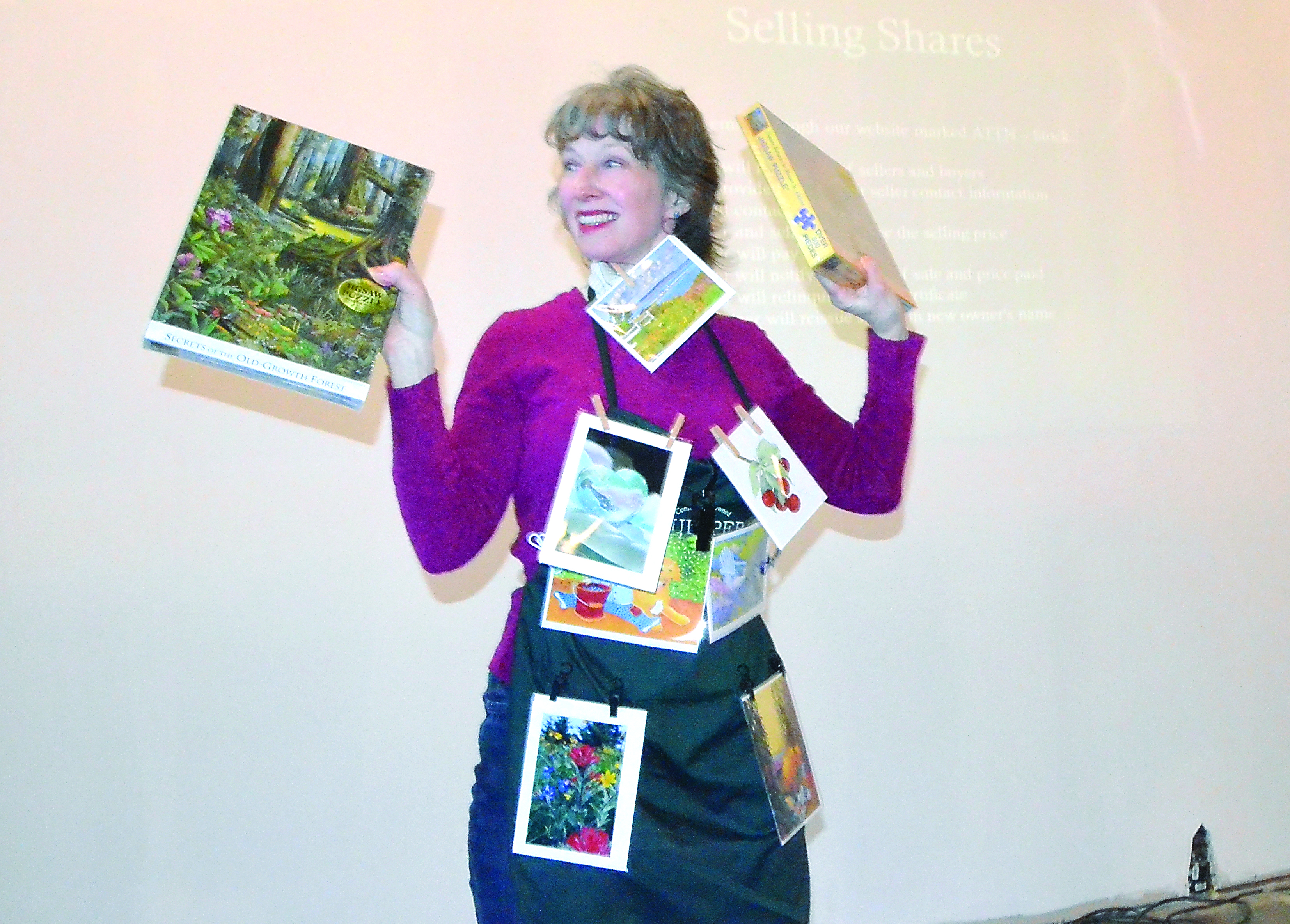 Dottie Nelson “models” some of the puzzles available at the Quimper Mercantile Co. in Port Townsend at a stockholders meeting Wednesday night. Charlie Bermant/Peninsula Daily News