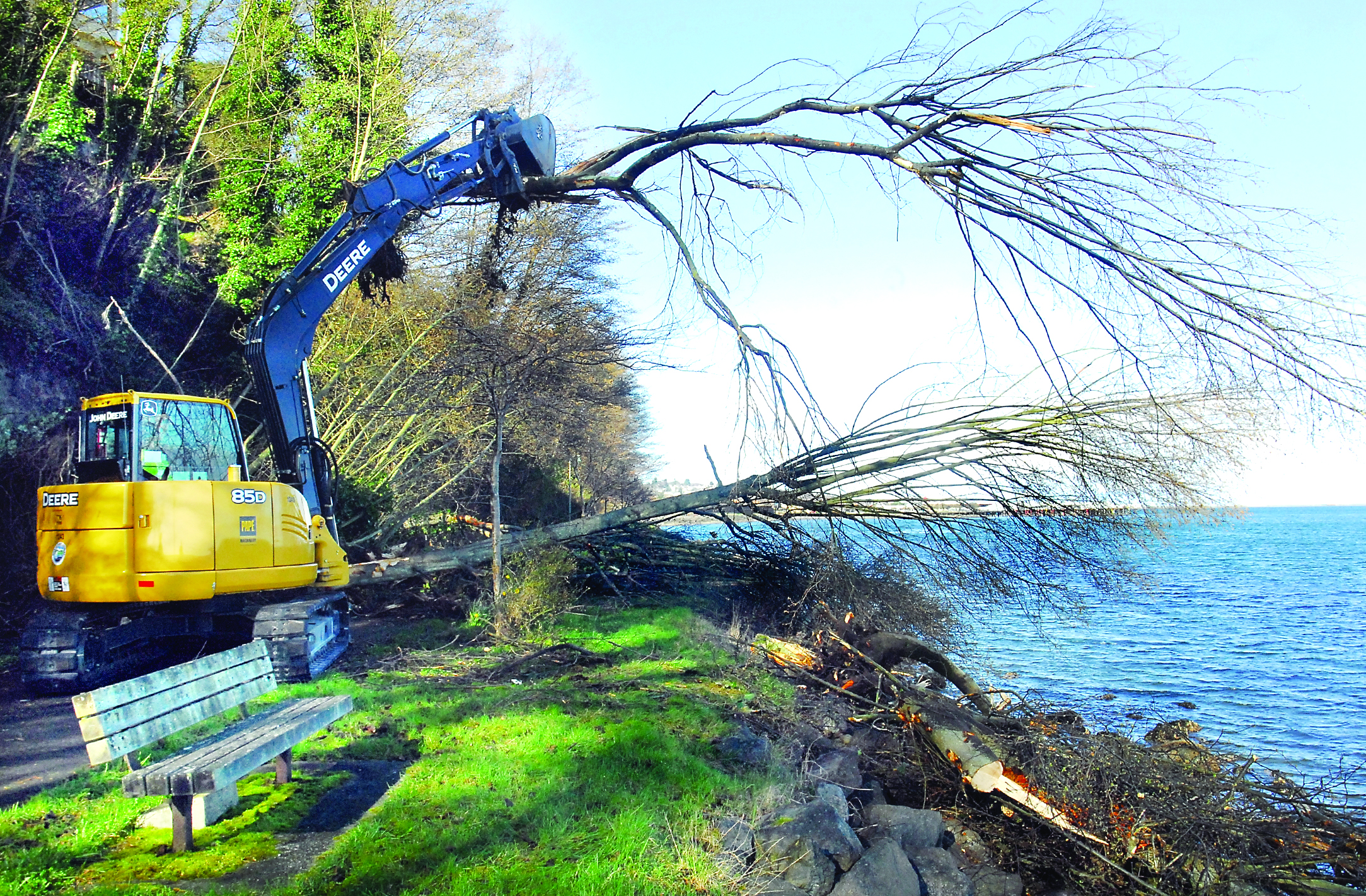 An excavator moves a tree to clear a section of the Waterfront Trail in Port Angeles on Thursday after a slide forced the closure of the trail. — Keith Thorpe/Peninsula Daily News