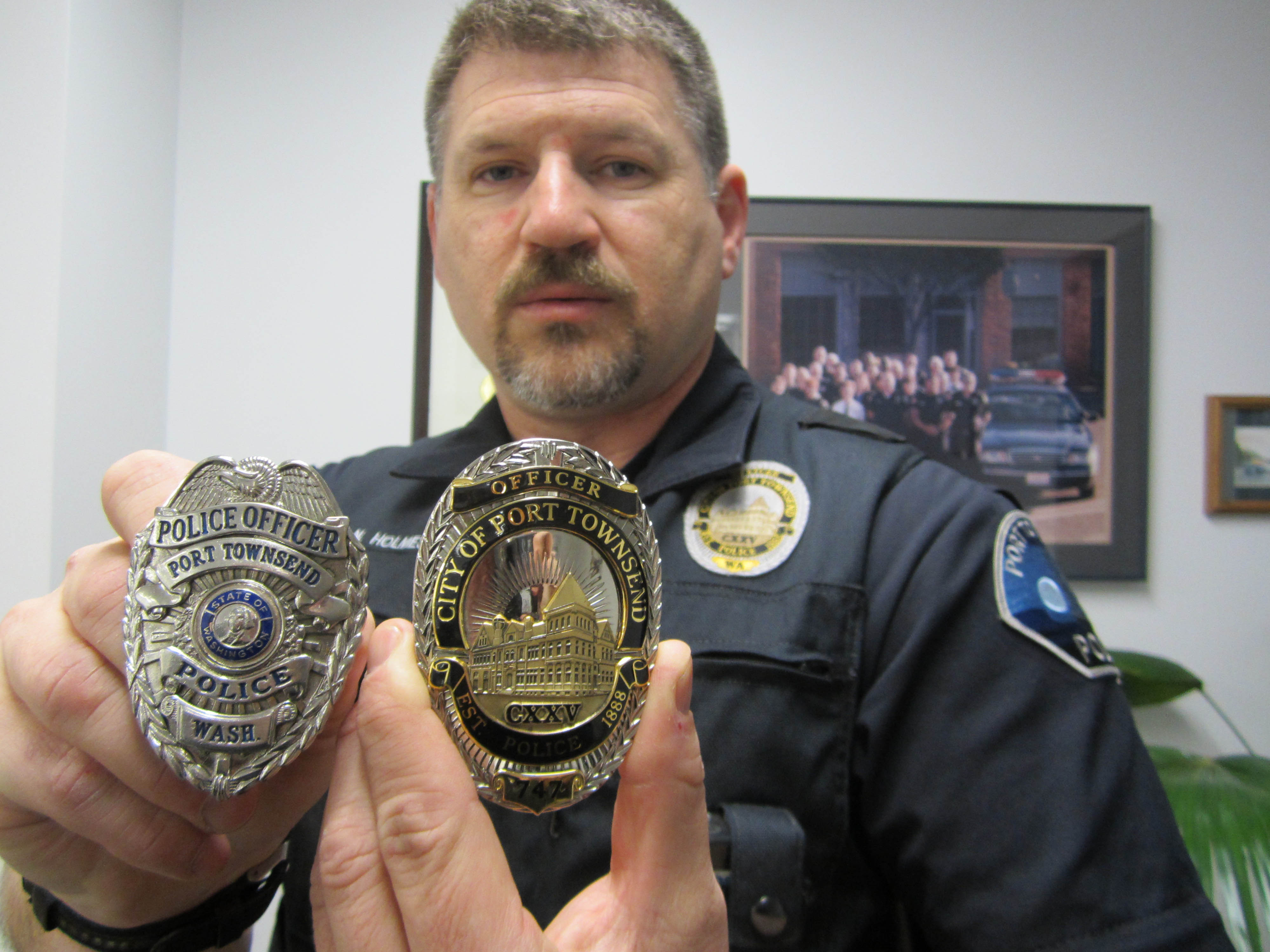 Officer Nate Holmes holds a badge formerly worn by Port Townsend Police Department officers