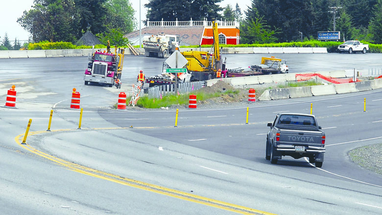 Construction crews put the finishing touches on a section of U.S. Highway 101 that crosses over a new underpass under the highway east of Deer Park Road near Port Angeles on Thursday while traffic continues to use a detour next to the construction zone. Keith Thorpe/Peninsula Daily News