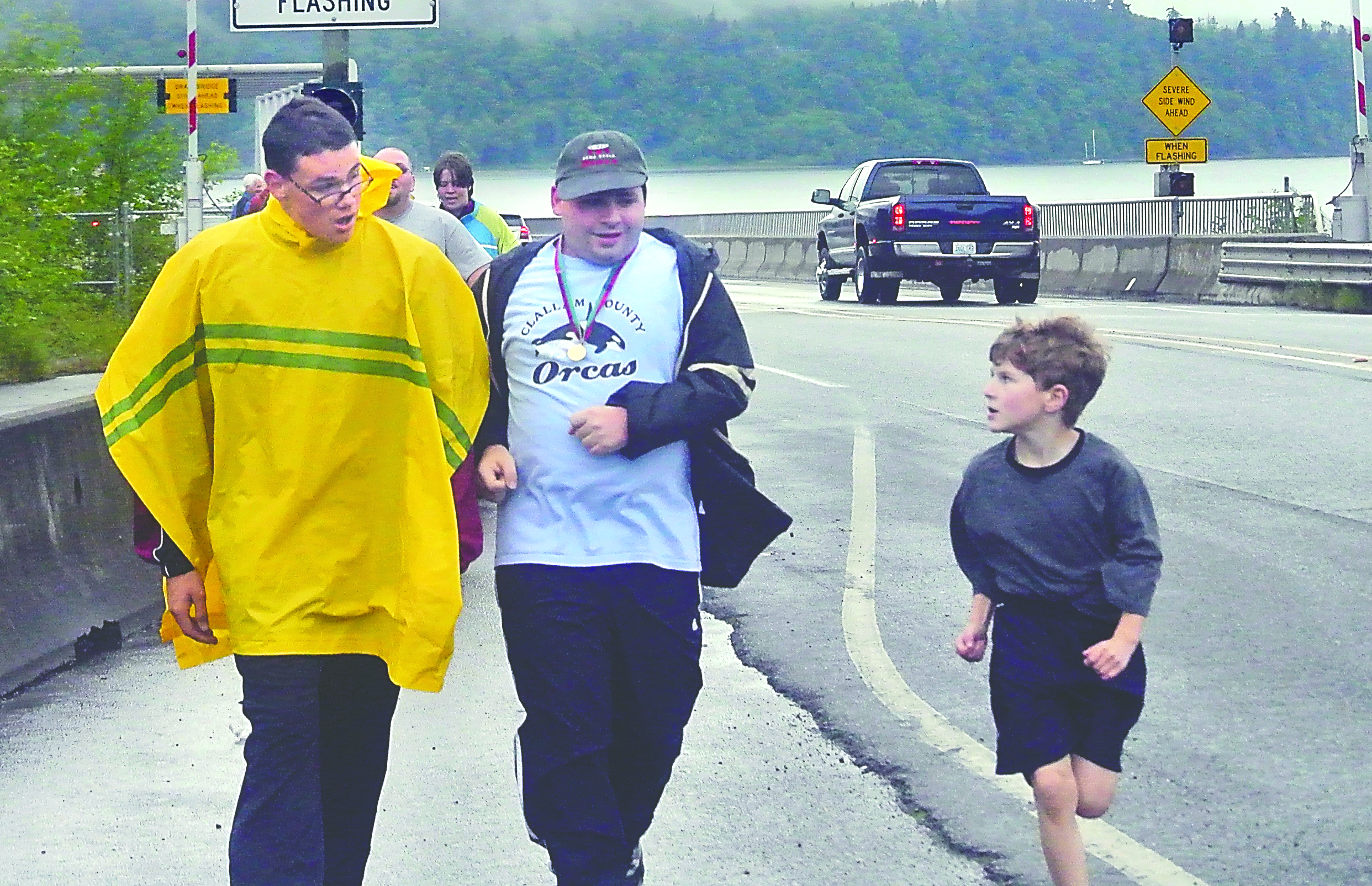Special Olympics runners Michael U’ren of Port Ludlow and Garet Bonham of Sequim are challenged by Samuel Holmes