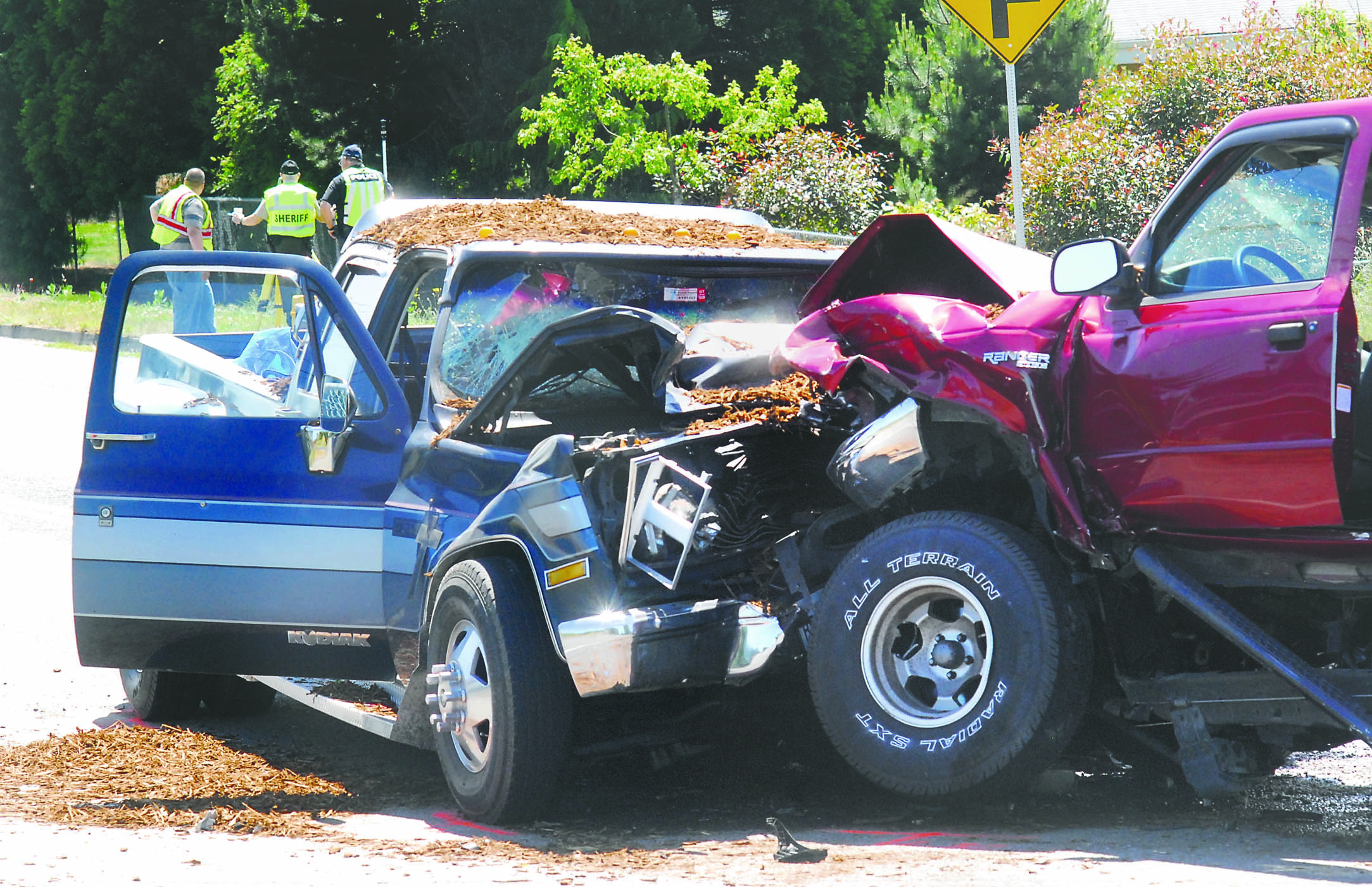 Accident investigators from the Clallam County Sheriff's Office and Sequim Police Department measure the scene of a collision between two pickup trucks on Old Olympic Highway near Mantle Road northwest of Sequim.  -- Photo by Keith Thorpe/Peninsula Daily News
