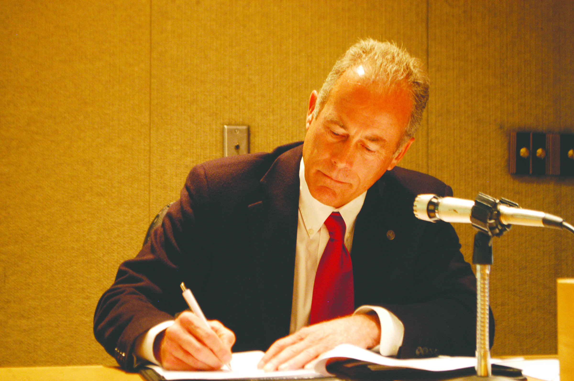 Jeff Robb signs his new contract at this morning's Port of Port Angeles Board of Commissioners meeting.  -- Photo by Paul Gottlieb/Peninsula Daily News