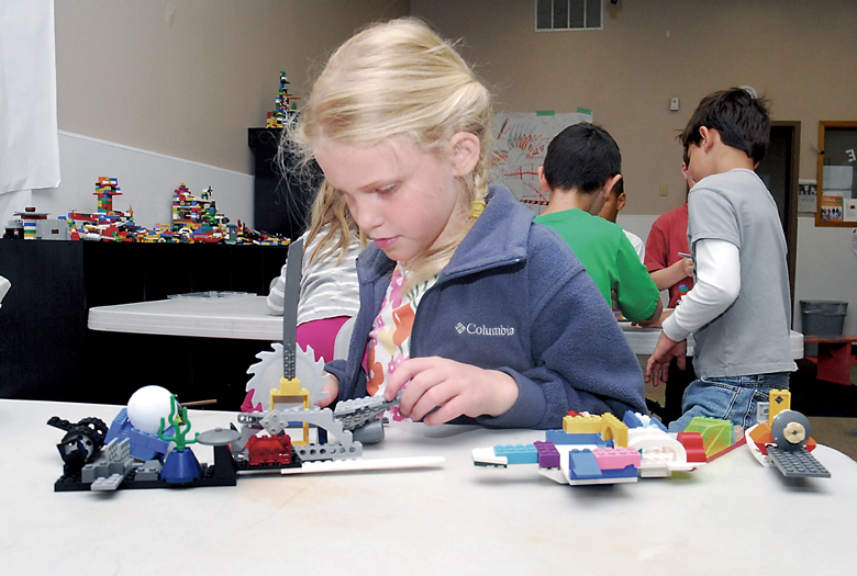 Seven-year-old Madeline Irwin constructs a catapult using Lego blocks at a “Lego Madness” youth camp at the Clallam County YMCA in Port Angeles on Thursday. Keith Thorpe/Peninsula Daily News