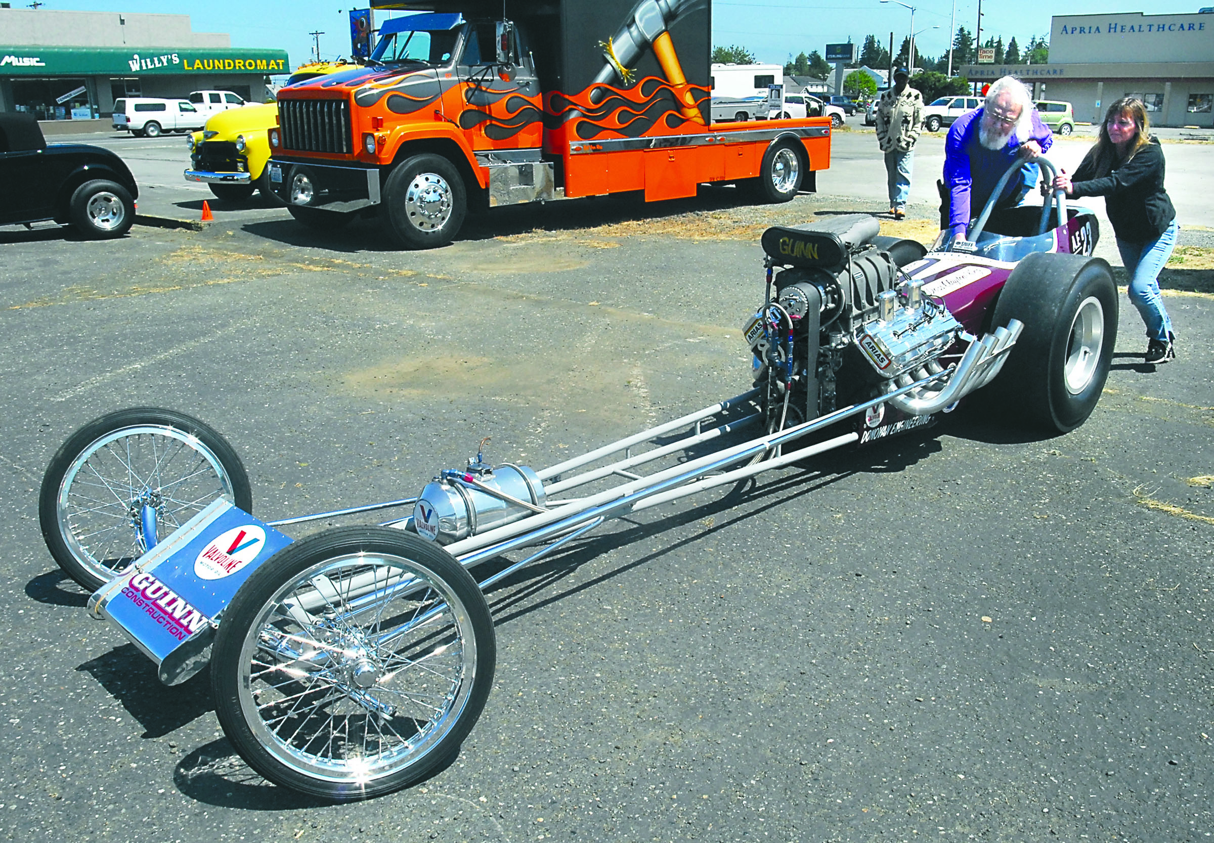 Wayne King of Gardiner and Mickey Griffith of Port Townsend push a 1963 top fuel dragster to its parking place at 2013's Darlene Marihugh Memorial Cruz-In in Port Angeles. Dozens of classic cars